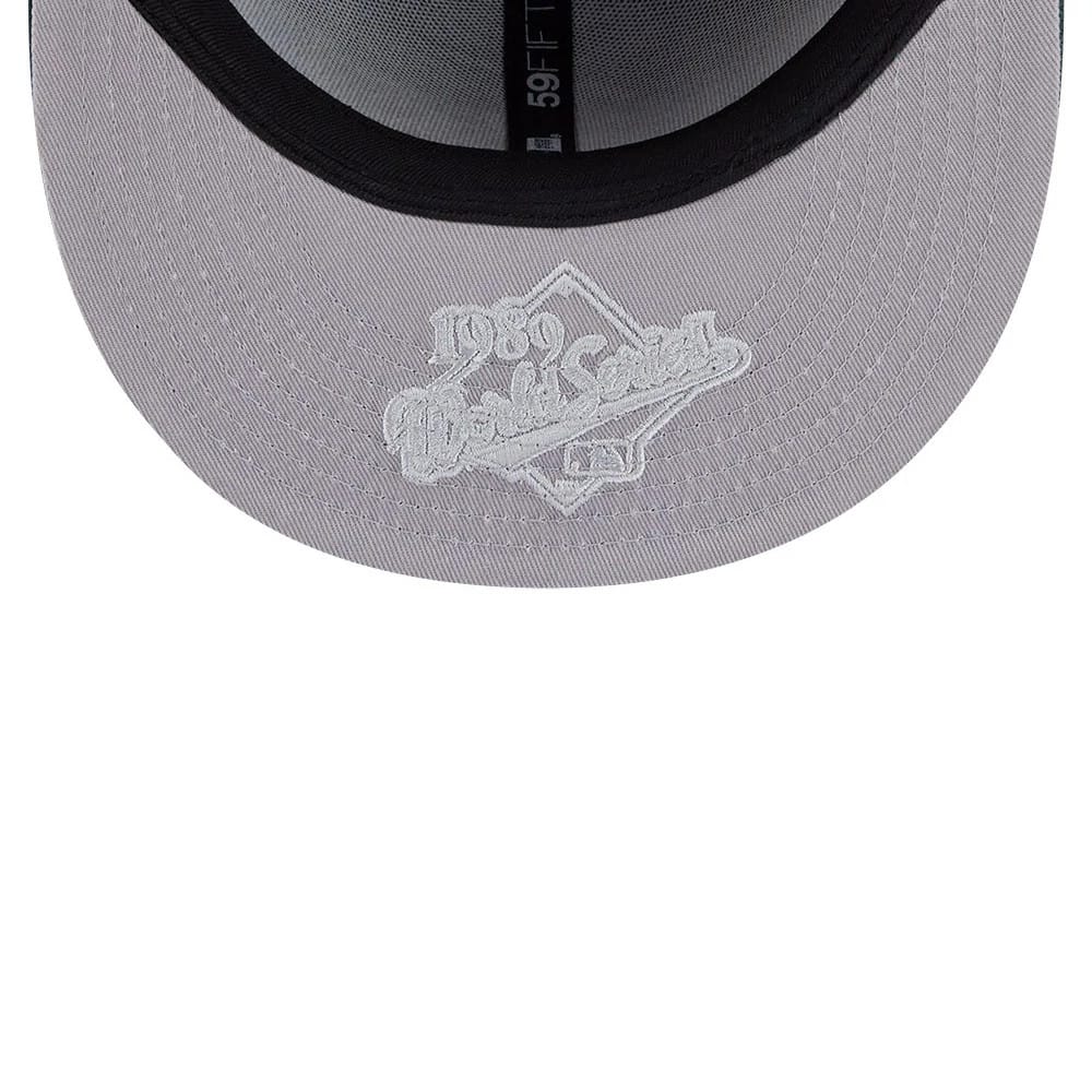 Athletics MLB Hidden Hit Dark Green New Era 59FIFTY Fitted Cap, inside view showing the grey undervisor with white embroidered 1989 World Series logo, black sweatband and black interior taping with 59FIFTY branding.