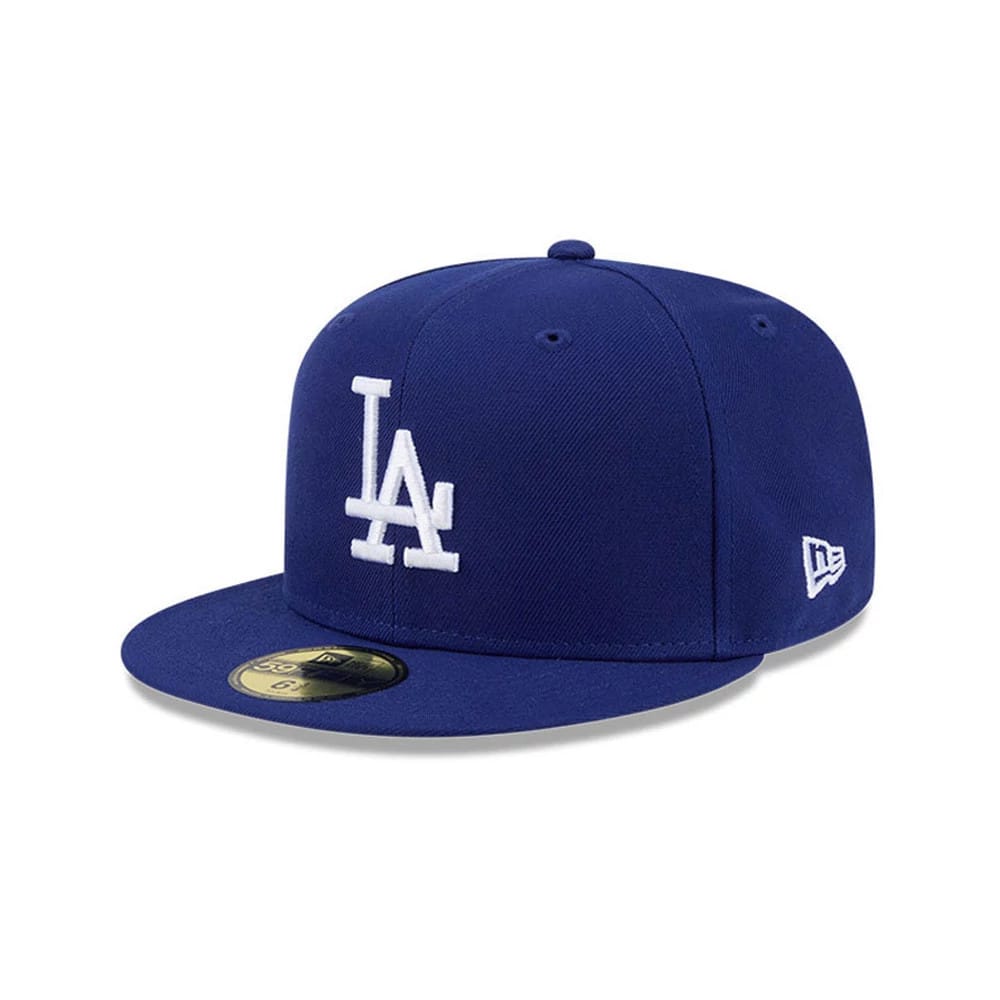 LA Dodgers MLB Hidden Hit Dark Blue New Era 59FIFTY Fitted Cap, three-quarter view showing the raised white LA logo embroidered on the front panel, matching dark blue visor with gold 59FIFTY size sticker, and New Era flag logo on the left side.