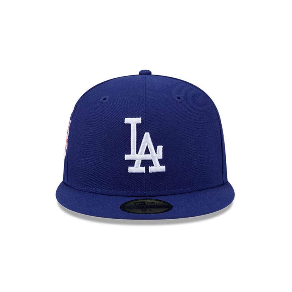 LA Dodgers MLB Hidden Hit Dark Blue New Era 59FIFTY Fitted Cap, front view showing white raised embroidered LA logo on the dark blue structured crown, with a flat visor and a gold 59FIFTY size sticker on the centre of the visor.