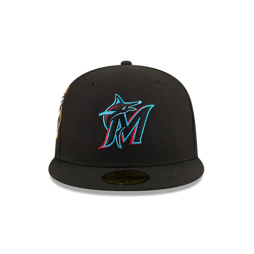 Miami Marlins MLB Hidden Hit Black New Era 59FIFTY Fitted Cap, front view showing the raised Miami Marlins logo embroidered in teal and red on the black front panel, with a gold 59FIFTY size sticker on the black flat visor.