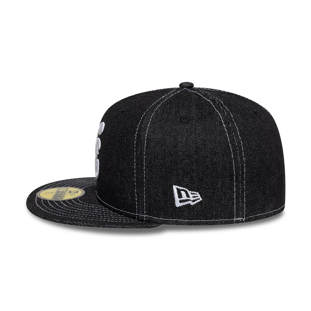New Era Denim Black 59FIFTY Fitted Cap, side view showing a white New Era flag logo on the left side with a structured black denim crown and a flat visor featuring a gold 59FIFTY size sticker.