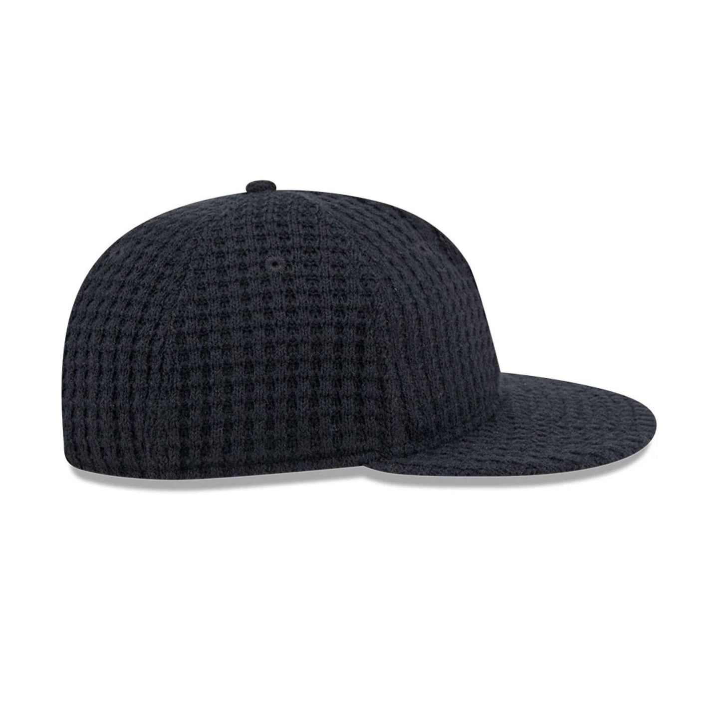 New Era Waffle Knit Navy Retro Crown 9FIFTY Adjustable Cap, side view showing the unique textured waffle knit pattern on the structured navy crown and flat visor, with minimalistic design and no logos.