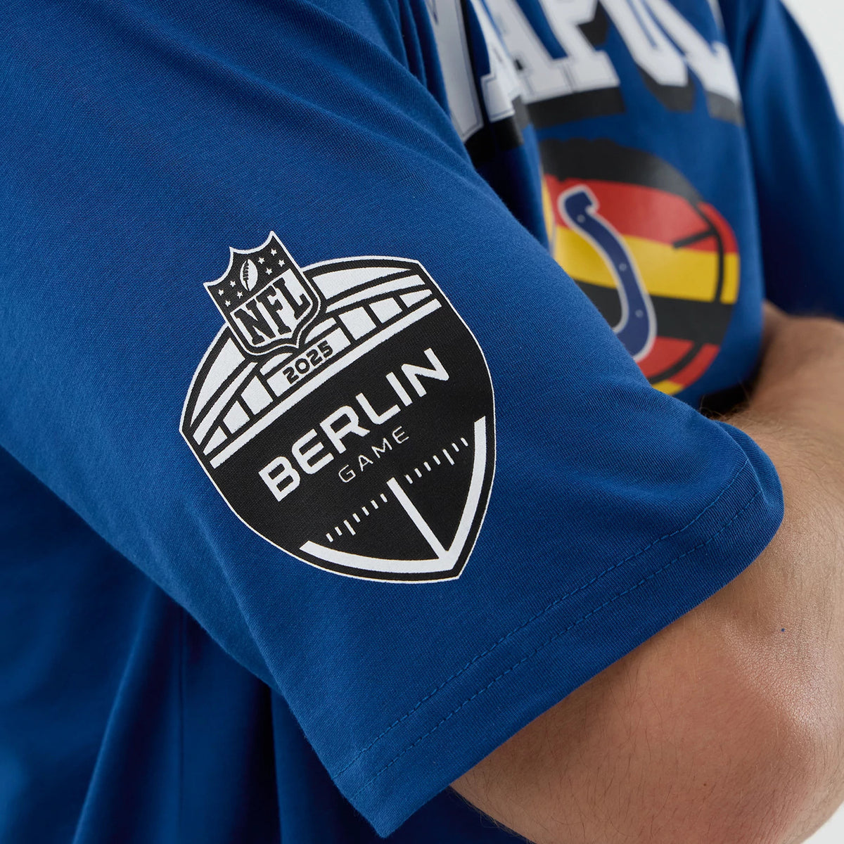 New Era Colts NFL International Series Games Script Blue Oversized T-Shirt, side view showing the Berlin Game 2023 logo printed on the sleeve, with a colourful Colts graphic on the chest area.