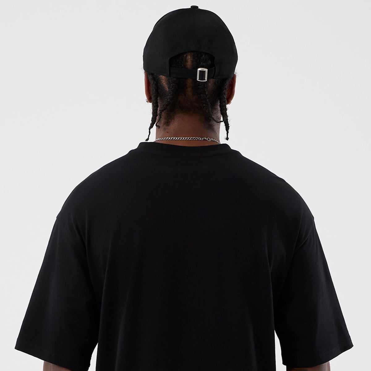 New Era Berlin NFL International Series Games Black Oversized T-Shirt, back view on a model showing the plain black back with its relaxed fit, short sleeves, and loose hem extending past the waist.