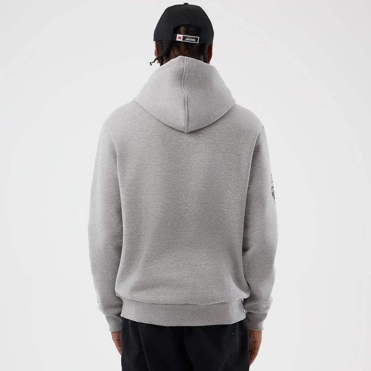 New Era Jacksonville Jaguars NFL International Series Games Grey Pullover Hoodie, back view showing the plain grey back with a spacious hood on a model, highlighting the simple design without graphics or logos from this angle.