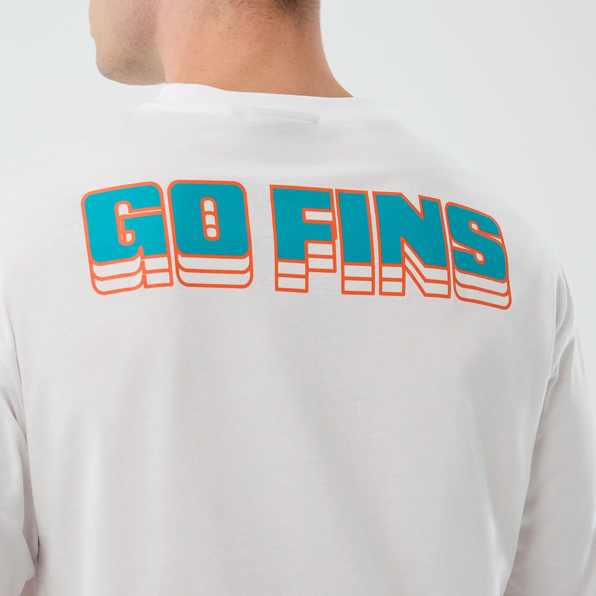 New Era Dolphins NFL International Series Games Madrid White Oversized T-Shirt, back view on a model showing GO FINS text in blue with orange outline across the upper back of the white fabric.