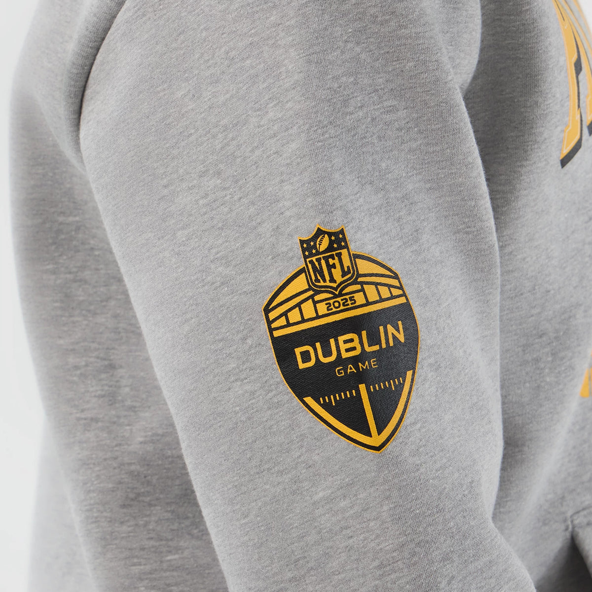 New Era Pittsburgh Steelers NFL International Series Games Grey Pullover Hoodie, side view highlighting a yellow and black printed 2025 Dublin Game NFL badge on the left sleeve of the grey hoodie.