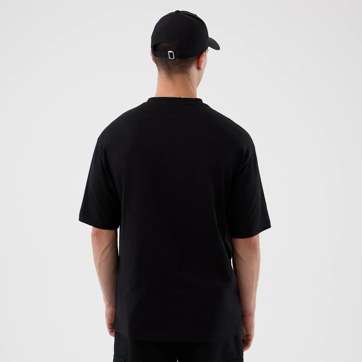 New Era Dublin Game NFL International Series Games Black Oversized T-Shirt, back view on a model with plain black styling, showing the solid black colour and relaxed fit with short sleeves and a straight hemline.