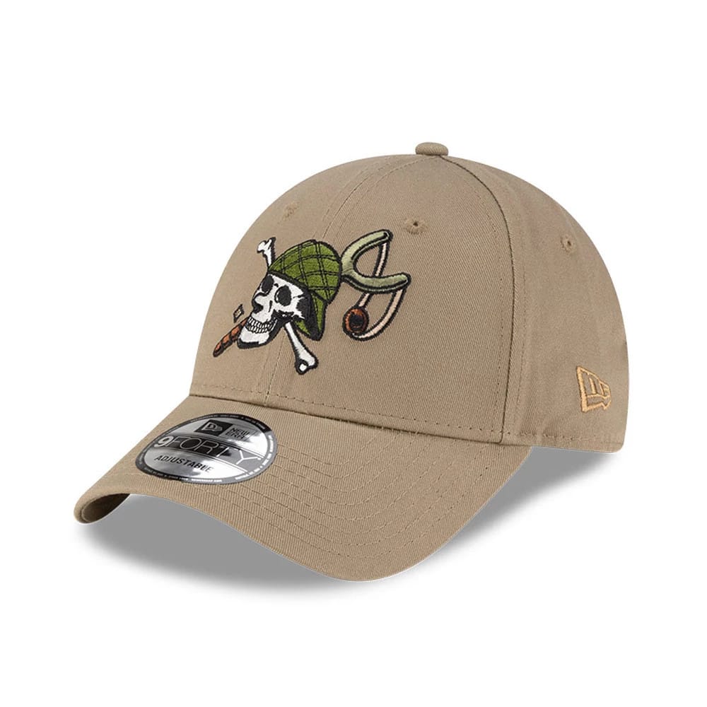 One Piece Usopp Beige New Era 9FORTY Adjustable Cap, three-quarter view showing a detailed embroidered white skull with a green hat on the front panel, a curved beige visor with a 9FORTY size sticker, and the New Era flag logo on the left side.