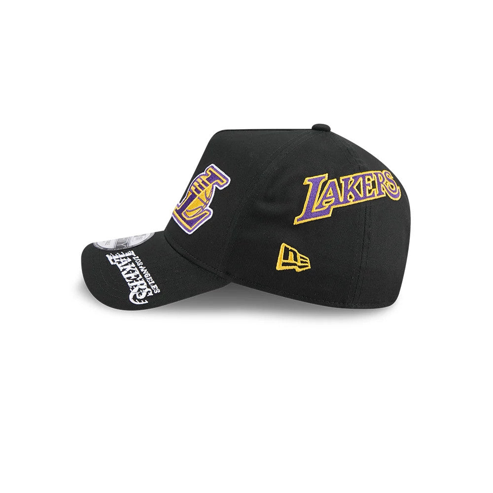 LA Lakers NBA All Over Black New Era 9FORTY A-Frame Adjustable Cap, side view showing a yellow New Era flag logo on the left side, with purple and gold Lakers lettering on the black structured crown and various graphics on the visor.