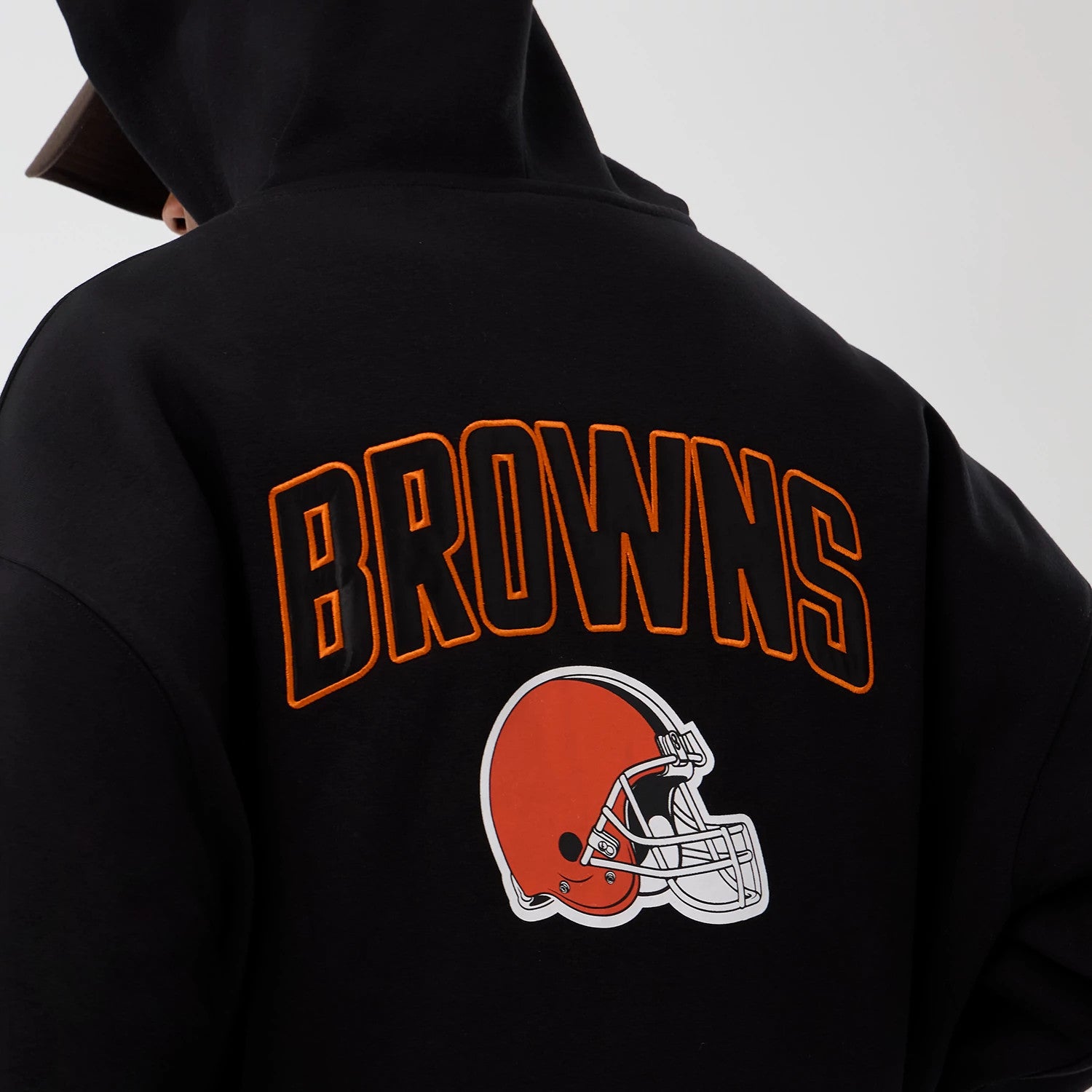 New Era Cleveland Browns NFL International Series Games Black Full Zip Hoodie, back view showing orange BROWNS lettering outlined in black above the printed orange and white helmet graphic on a black background.
