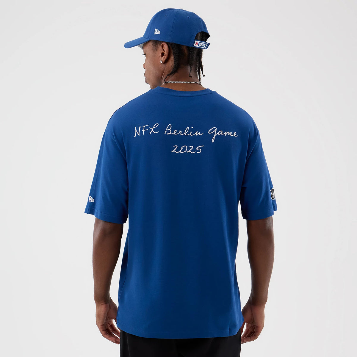 New Era Colts NFL International Series Games Berlin Blue Oversized T-Shirt, back view on-model displaying NFL Berlin Game 2025 text across the upper back, with an embroidered New Era logo on the left sleeve.
