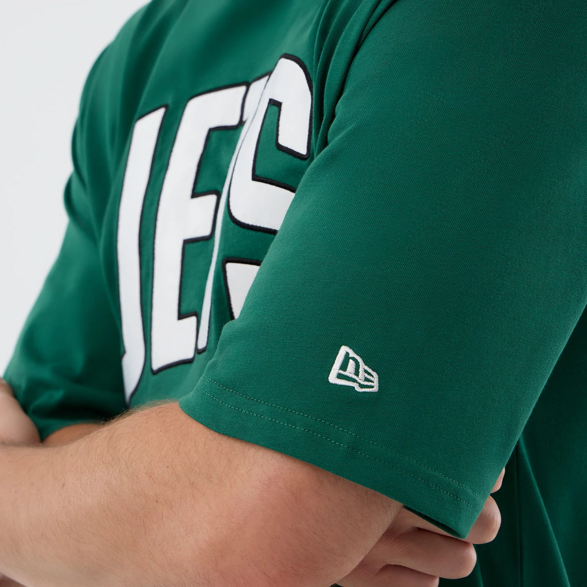 New Era New York Jets NFL International Series Games Green Oversized T-Shirt, three-quarter view of white JETS lettering across the chest and an embroidered New Era logo on the left sleeve, worn on-model for a casual style.