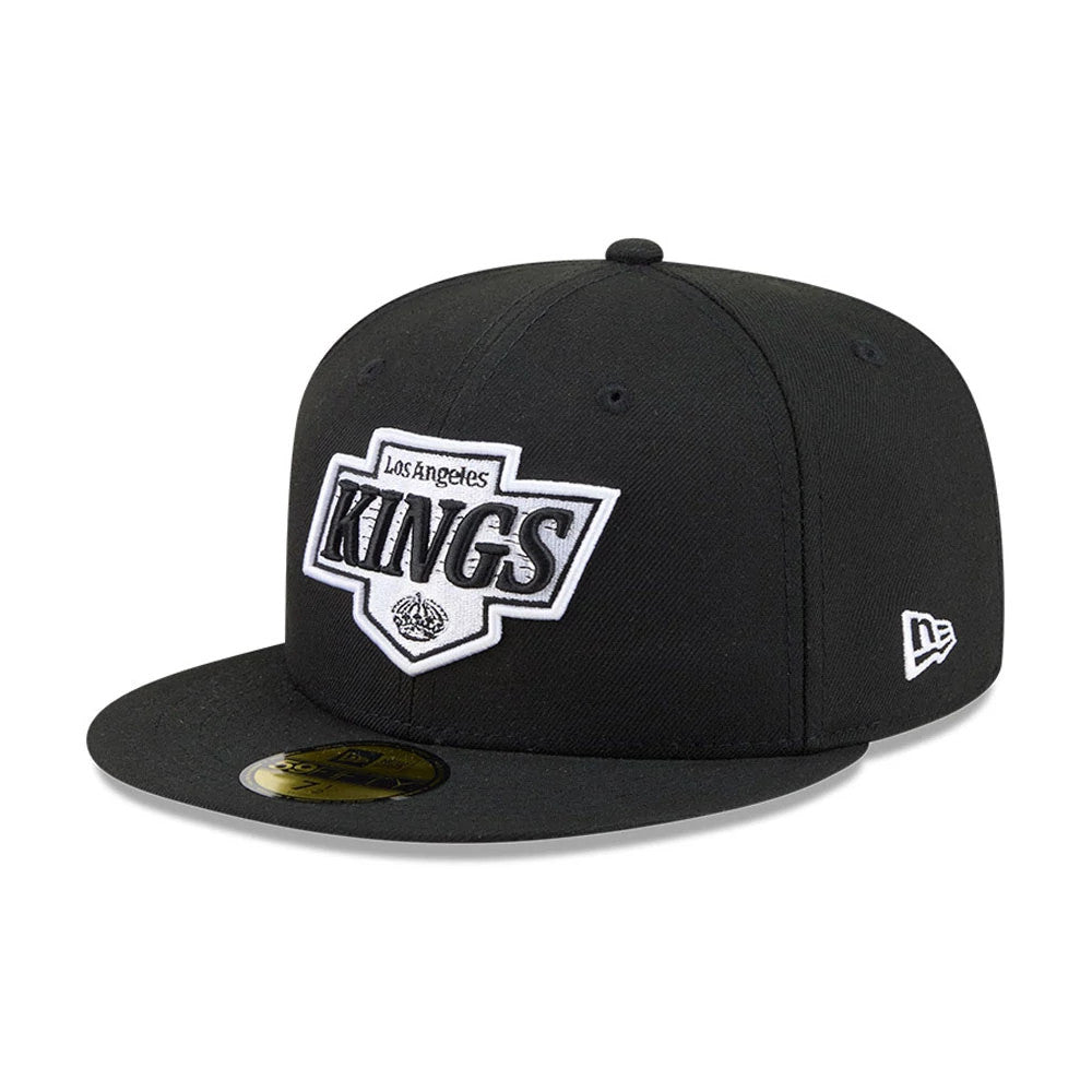 LA Kings NHL Evergreen Black New Era 59FIFTY Fitted Cap, three-quarter view showing the raised white and black embroidered LA Kings logo on the front panel, with a flat black visor and gold 59FIFTY size sticker.