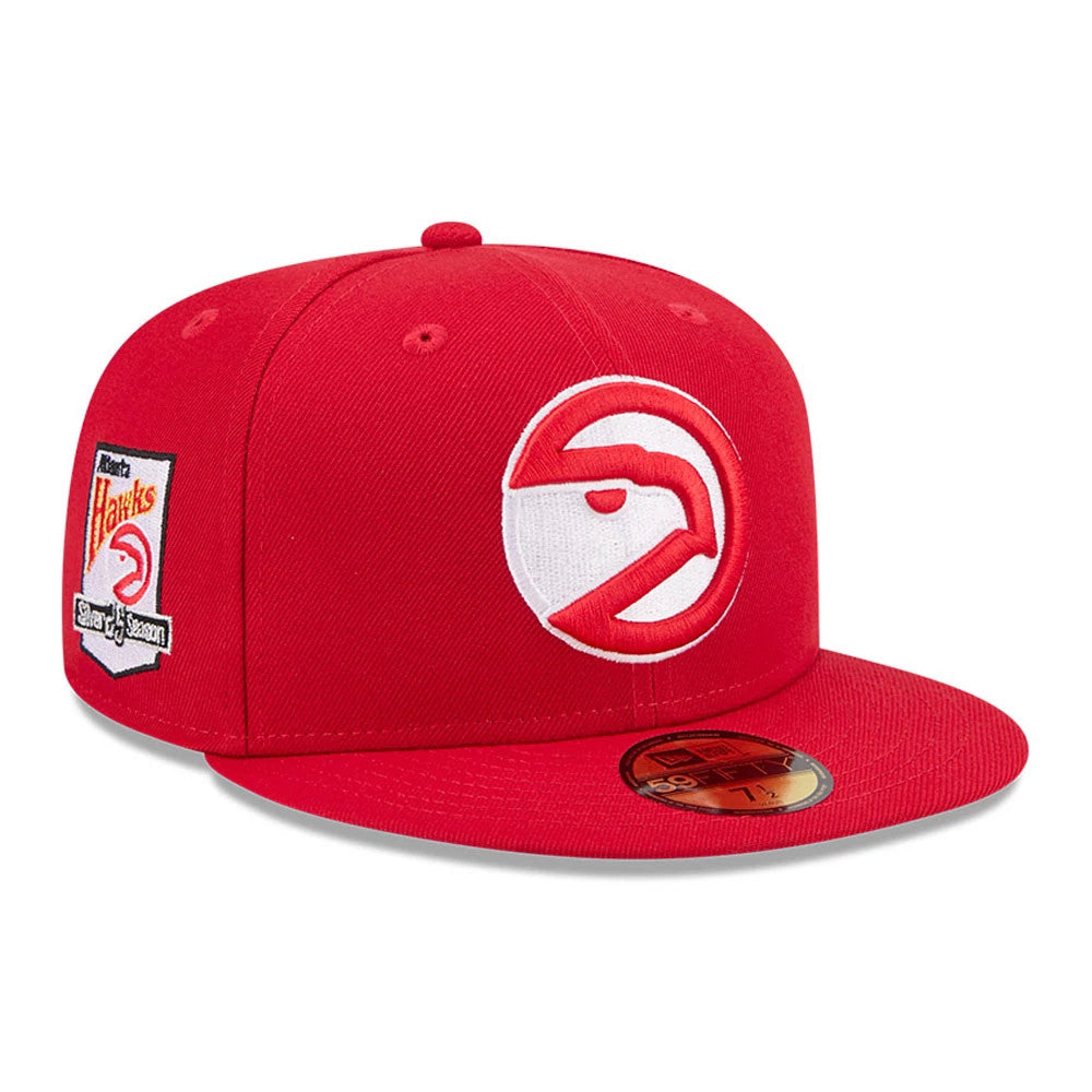 Atlanta Hawks NBA Hardwood Classic Red New Era 59FIFTY Fitted Cap, three-quarter view showing the raised red and white hawk logo on the front panel, with a red flat visor and gold 59FIFTY size sticker on top, and a team patch on the right side.