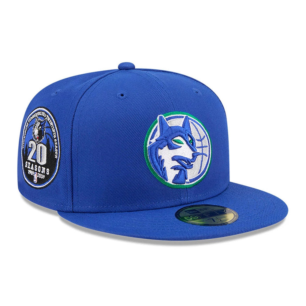 Minnesota Timberwolves NBA Hardwood Classic Blue New Era 59FIFTY Fitted Cap, three-quarter view showing a raised blue wolf logo in green and white embroidery on the front panel, with a commemorative patch on the right side.