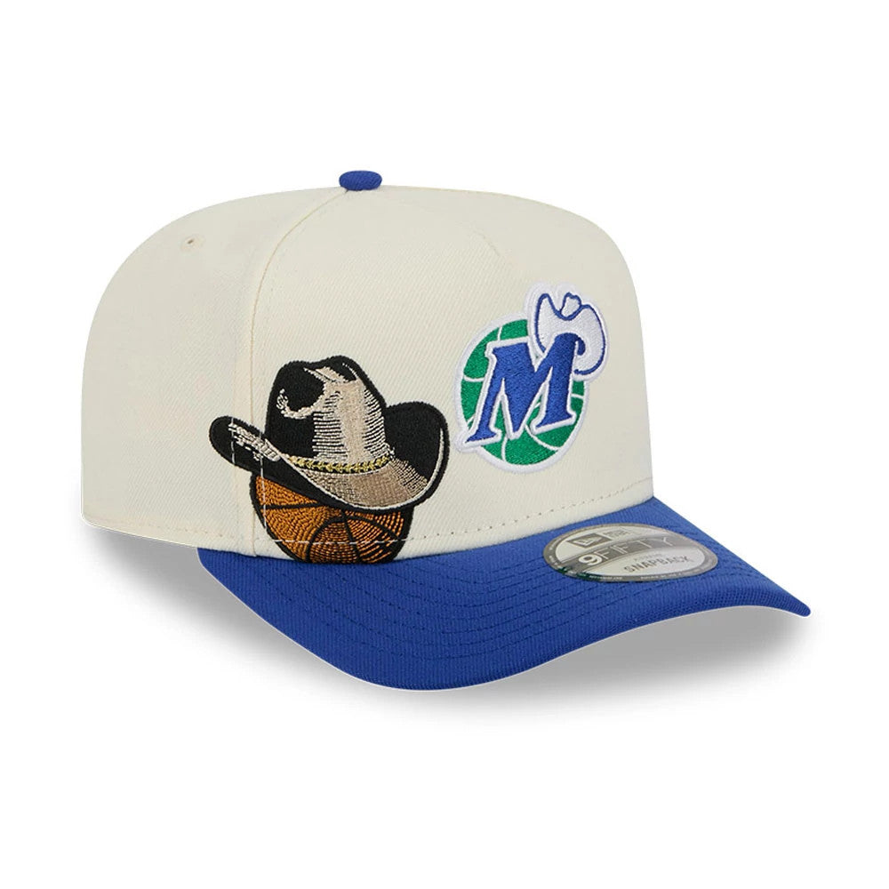 Dallas Mavericks NBA Blue New Era 9FIFTY A-Frame Snapback Adjustable Cap, three-quarter view showing the multicolour basketball and cowboy hat design on the front panel, with a raised M logo, blue visor, and a 9FIFTY size sticker.