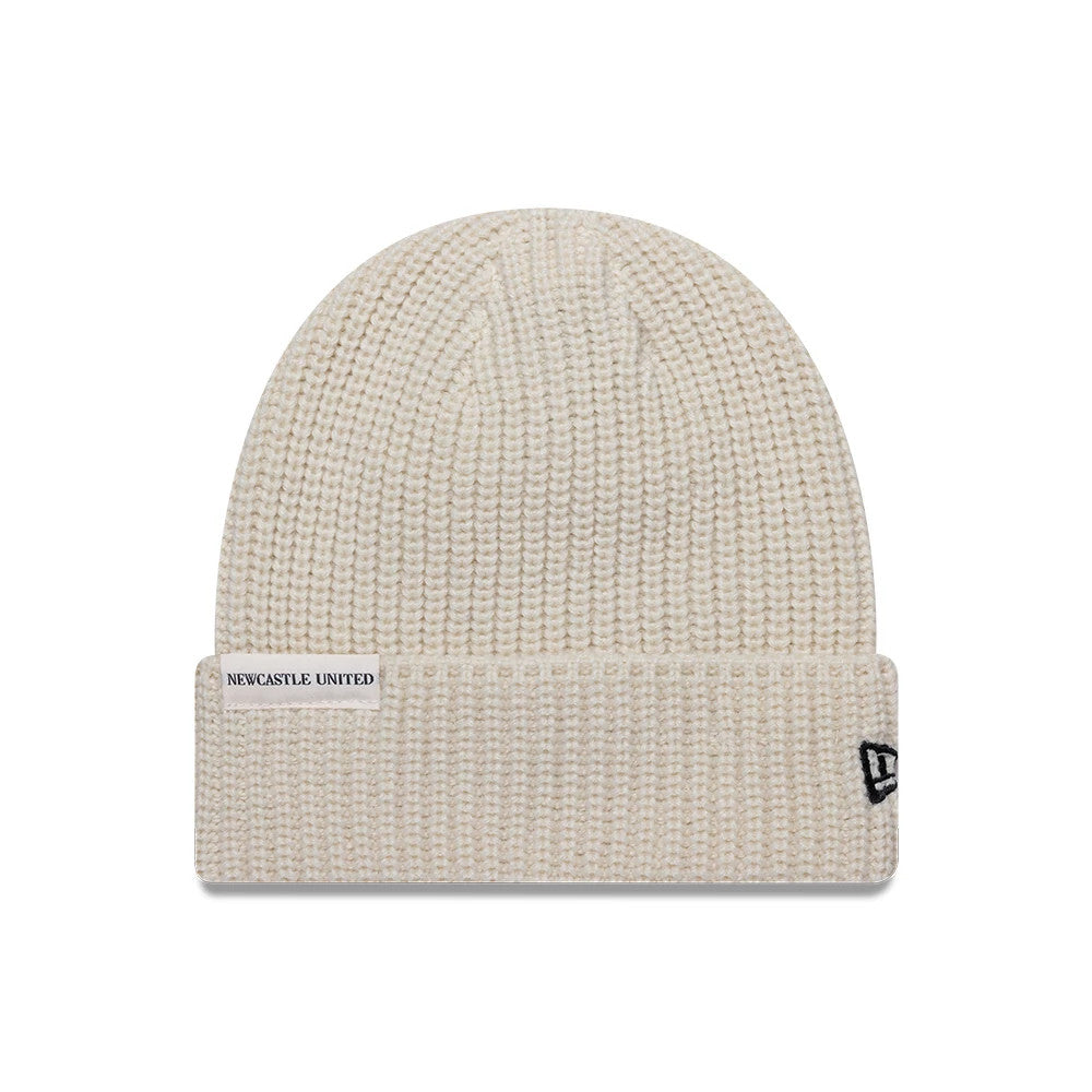 New Era Newcastle United FC Ribbed Light Beige Cuff Knit Beanie Hat, front view showing the Newcastle United patch on the cuff and the black embroidered New Era flag logo on the right side, with a textured ribbed design throughout.