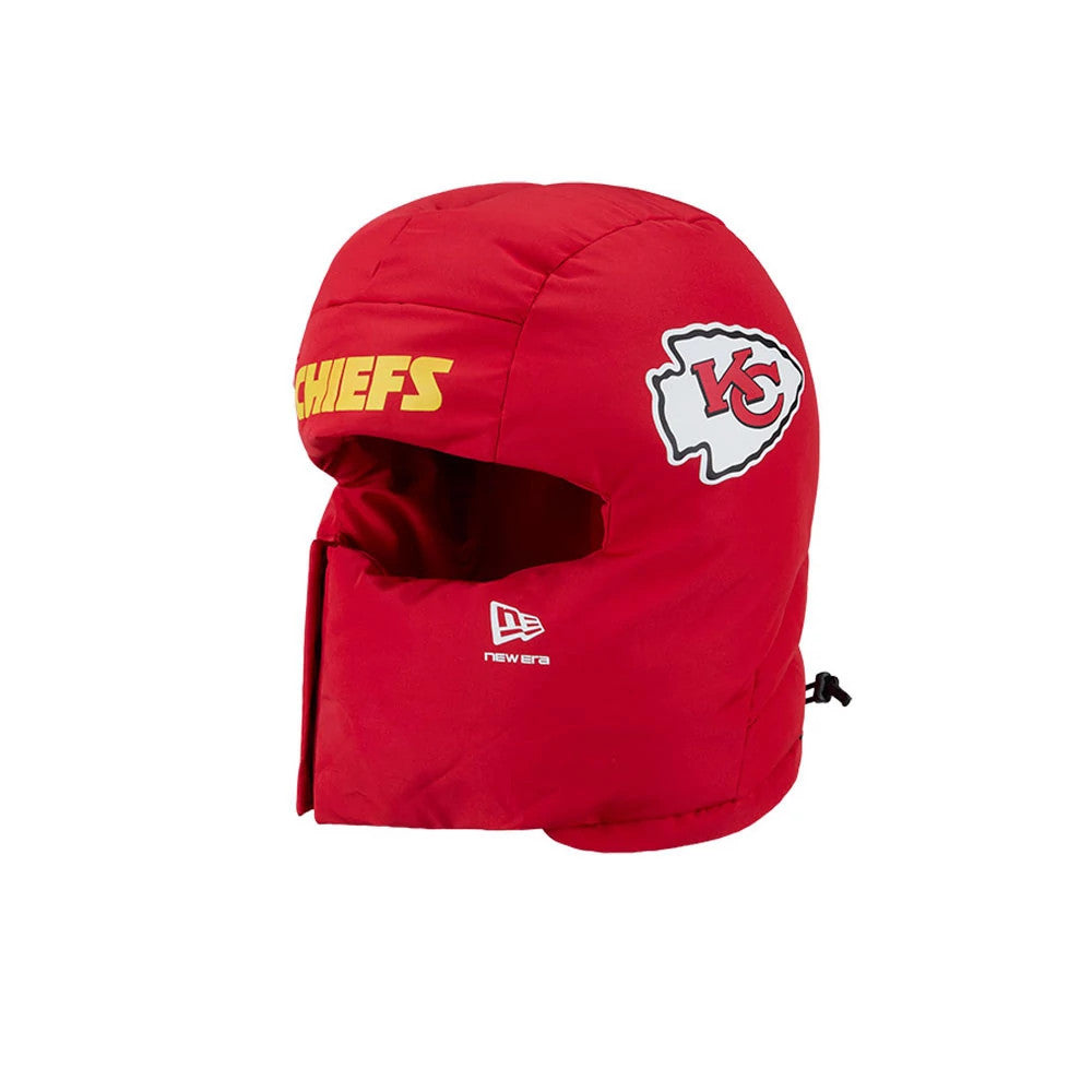 New Era Kansas City Chiefs NFL Puffer Helmet Red Trapper Hat, side view showing the Chiefs arrowhead logo on the left side, yellow CHIEFS lettering across the front, and a New Era logo in white on the lower left panel.