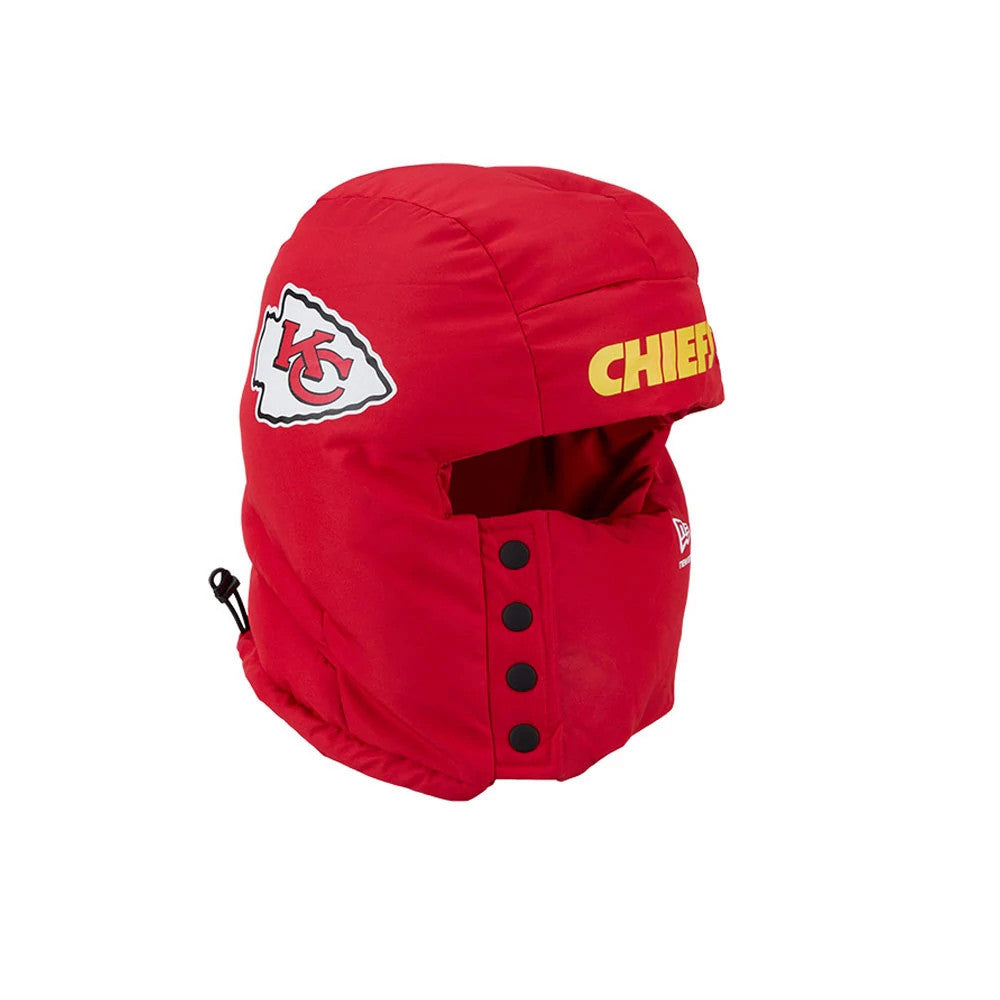 New Era Kansas City Chiefs NFL Puffer Helmet Red Trapper Hat, side view showing the embroidered Chiefs logo on the left side, yellow CHIEFS lettering on the front, and black snap buttons down the face covering.