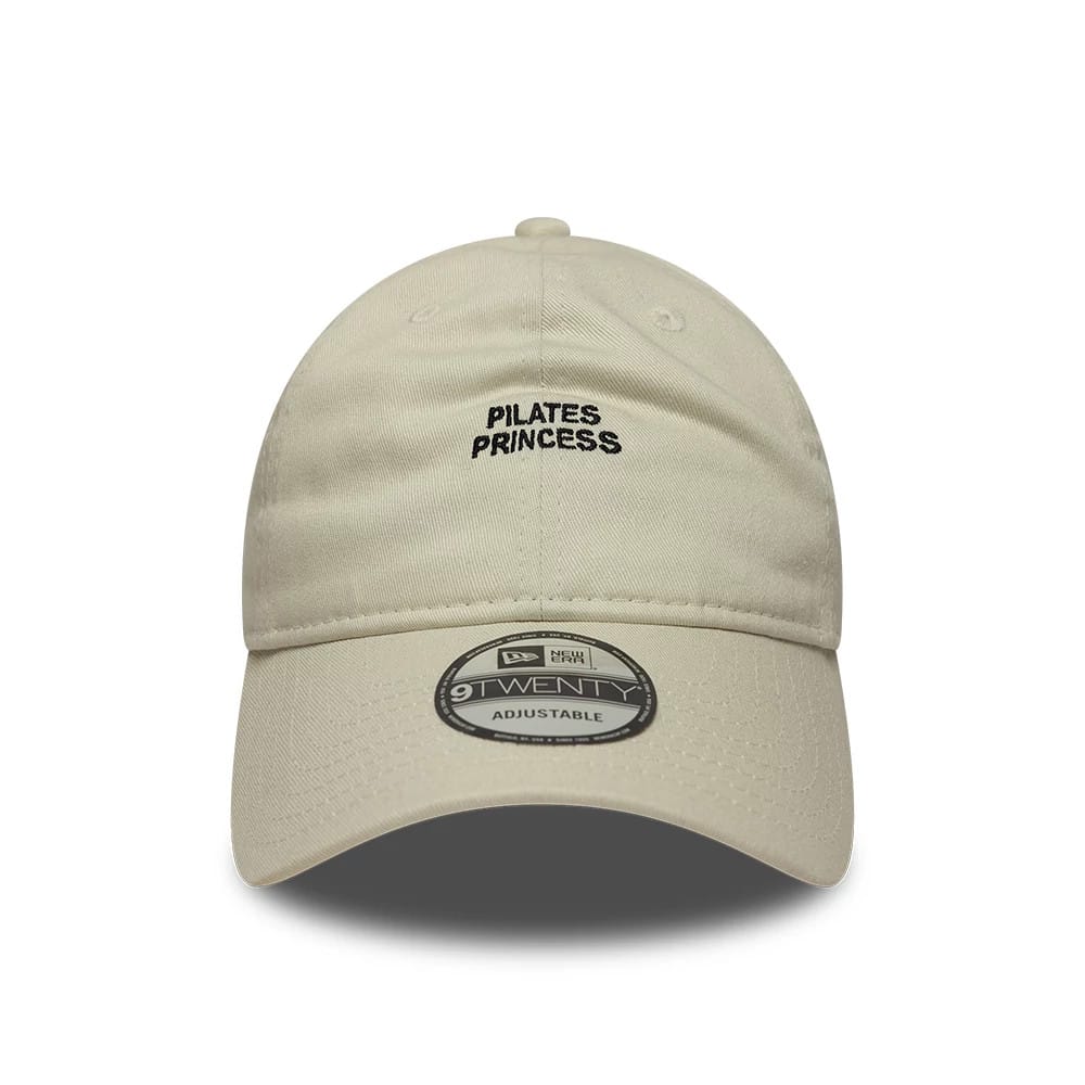 New Era Slogan Pilates Princess Light Beige 9TWENTY Adjustable Cap, front view showing black embroidered text on the unstructured crown, with a curved visor and 9TWENTY size sticker on the visor.