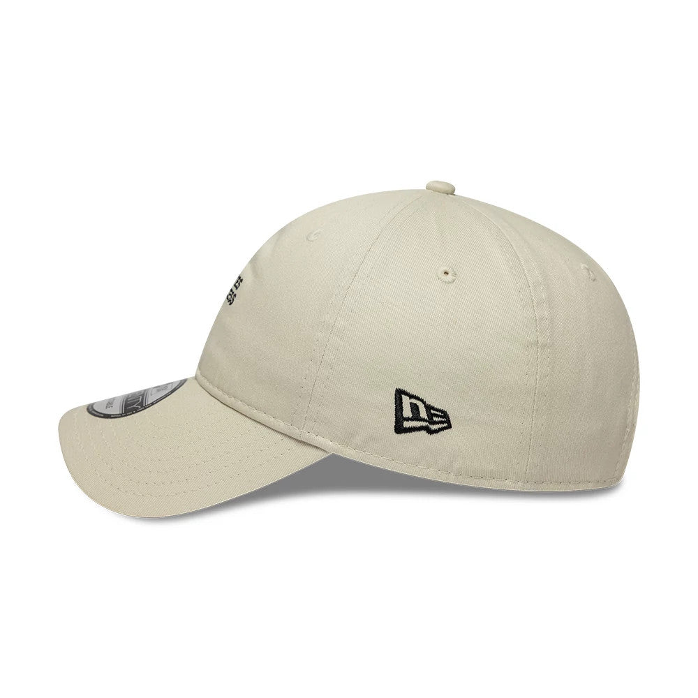 New Era Slogan Pilates Princess Light Beige 9TWENTY Adjustable Cap, side view showing the black embroidered New Era flag logo on the left side, with a soft curved visor and 9TWENTY size sticker.