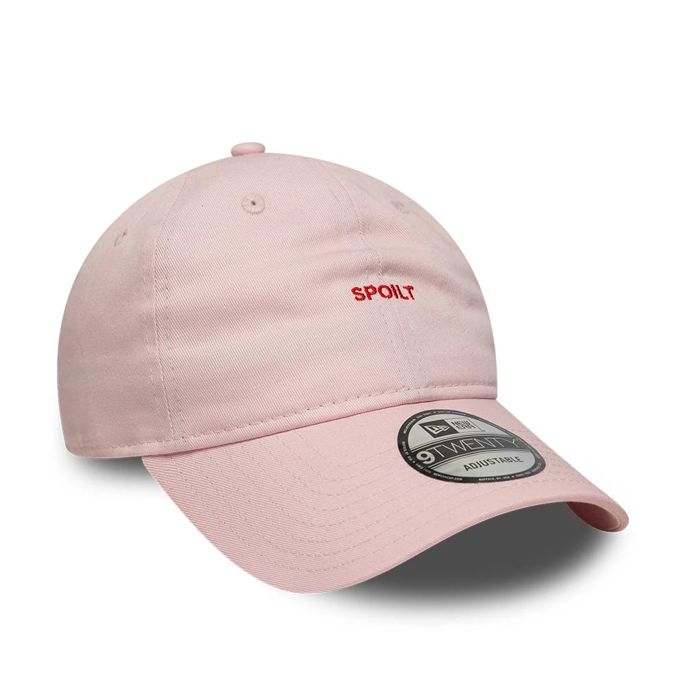 New Era Slogan Spoilt Pastel Pink 9TWENTY Adjustable Cap, three-quarter view showing the red embroidered Spoilt text on the front panel, with a curved pastel pink visor and a 9TWENTY size sticker on top.