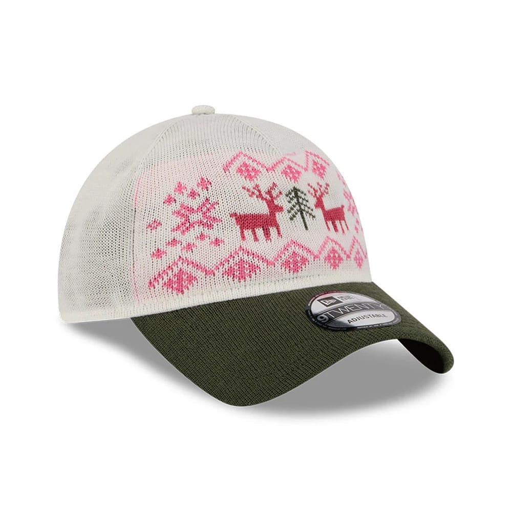 New Era Holiday Essentials White 9TWENTY Adjustable Cap, three-quarter view showing a pink and green festive pattern with reindeer and snowflakes on the white crown, complemented by a dark green curved visor and a 9TWENTY size sticker.