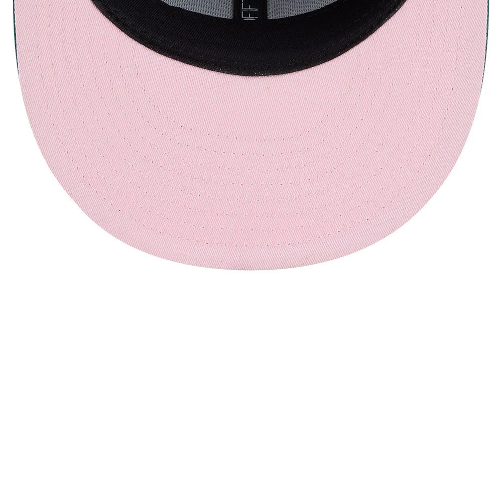 A Christmas Story Warner Brothers Green New Era 59FIFTY Fitted Cap, inside view showing a pink undervisor, black sweatband, and grey taping, highlighting the contrast stitching and structured interior design.