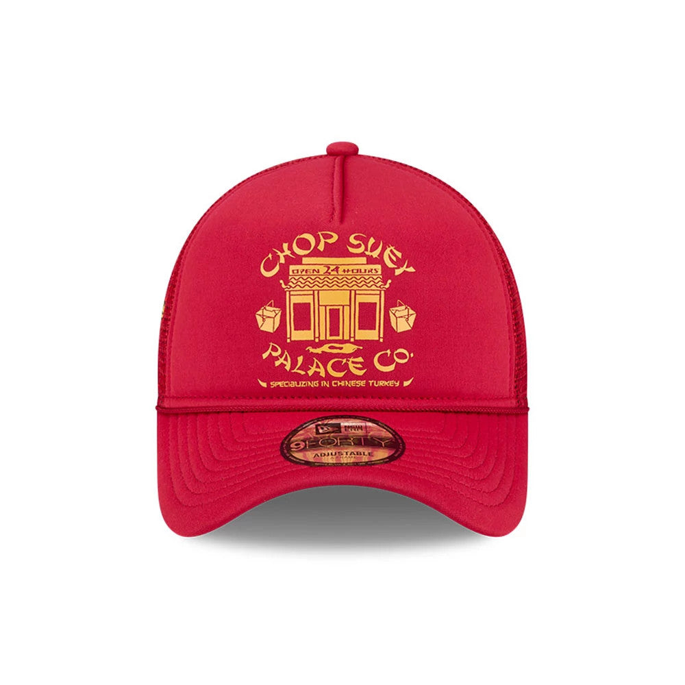 A Christmas Story Red New Era 9FORTY A-Frame Trucker Adjustable Cap, front view showing a yellow embroidered Chop Suey Palace Co. graphic on the structured red front panel, with a 9FORTY size sticker on the curved red visor.