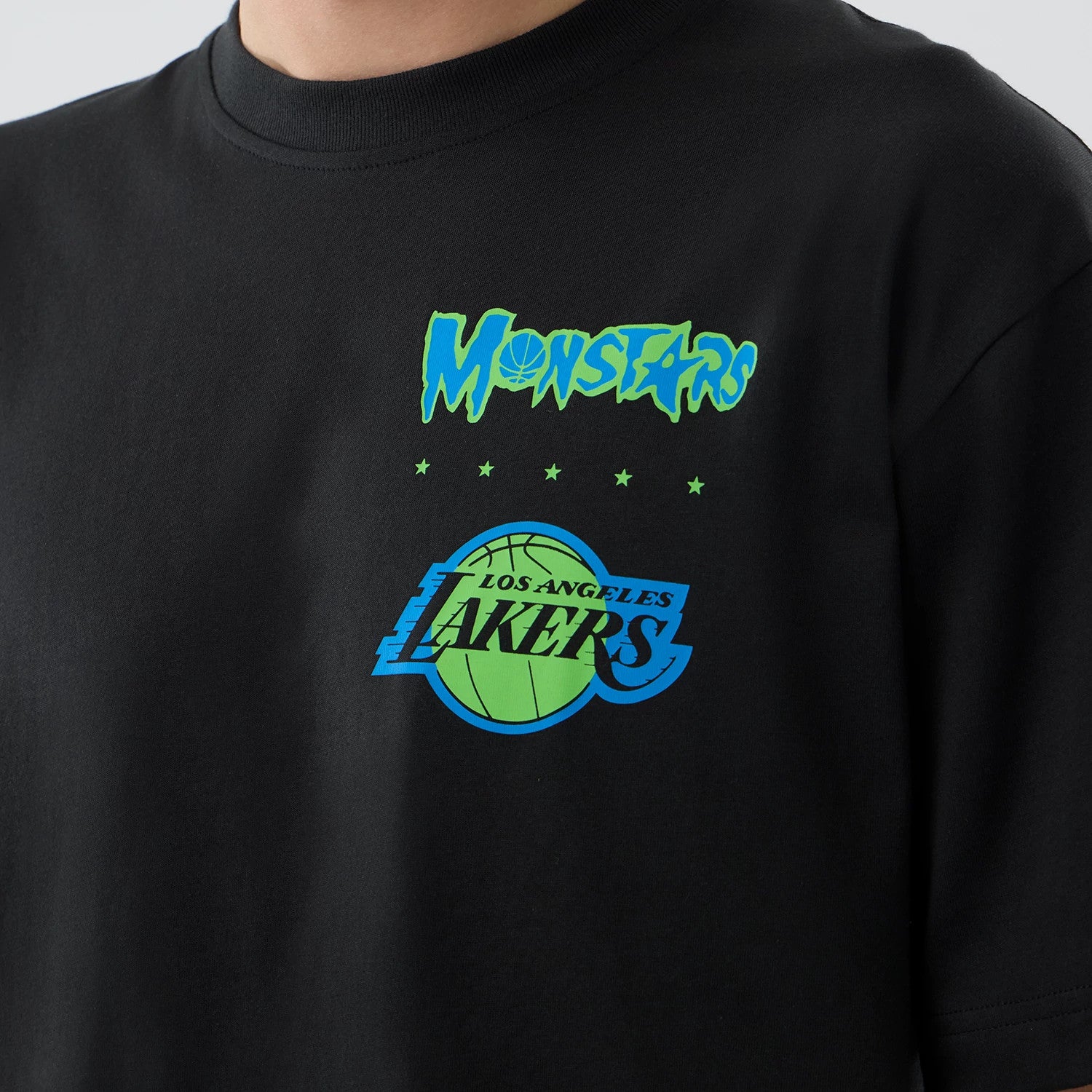 New Era LA Lakers Space Jam 2 X NBA Black T-Shirt, front view showing a green and blue Monstars graphic above a matching Los Angeles Lakers logo with a basketball design on the chest.