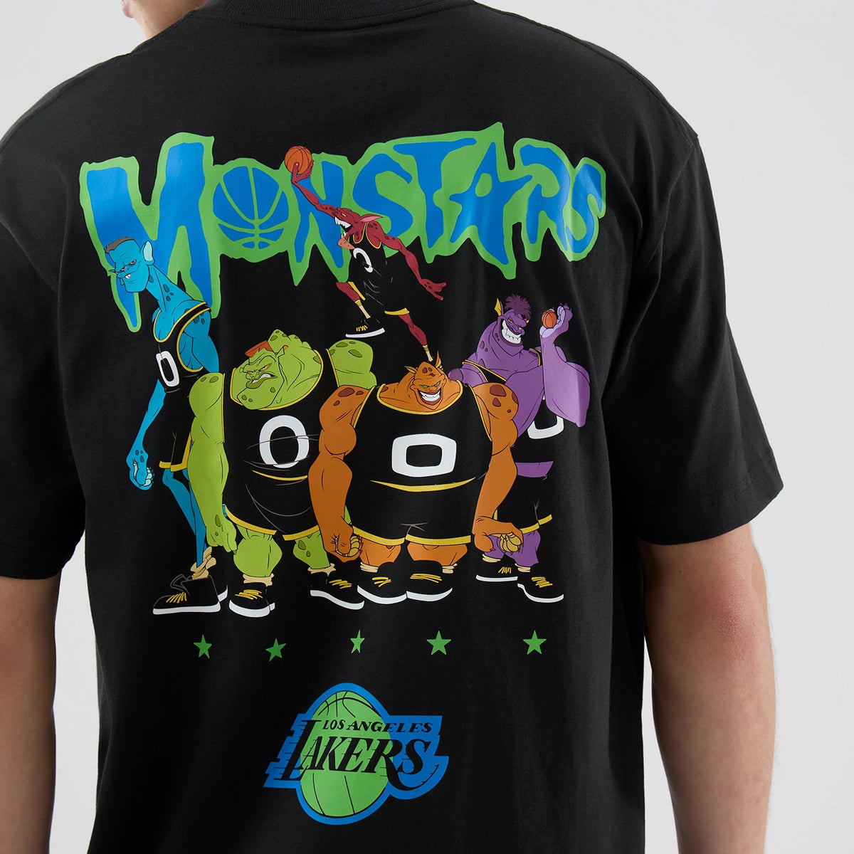 New Era LA Lakers Space Jam 2 X NBA Black T-Shirt, back view with colourful Monstars graphic and lettering across the upper back, featuring a large Los Angeles Lakers logo near the hem above five green stars.