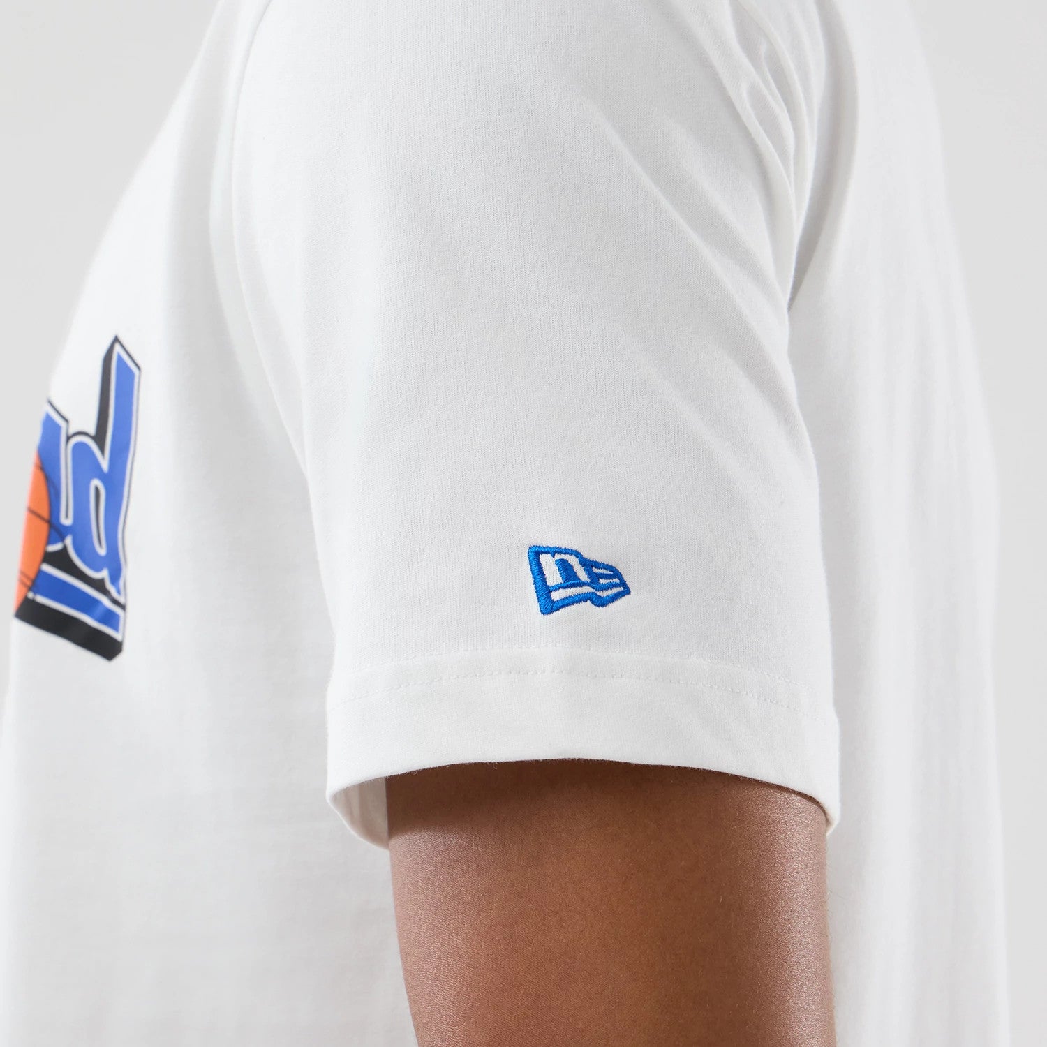 New Era Chicago Bulls Space Jam 2 X NBA White T-Shirt, side view highlighting the blue embroidered New Era logo on the left sleeve and the graphic of red basketball lettering across the upper back.