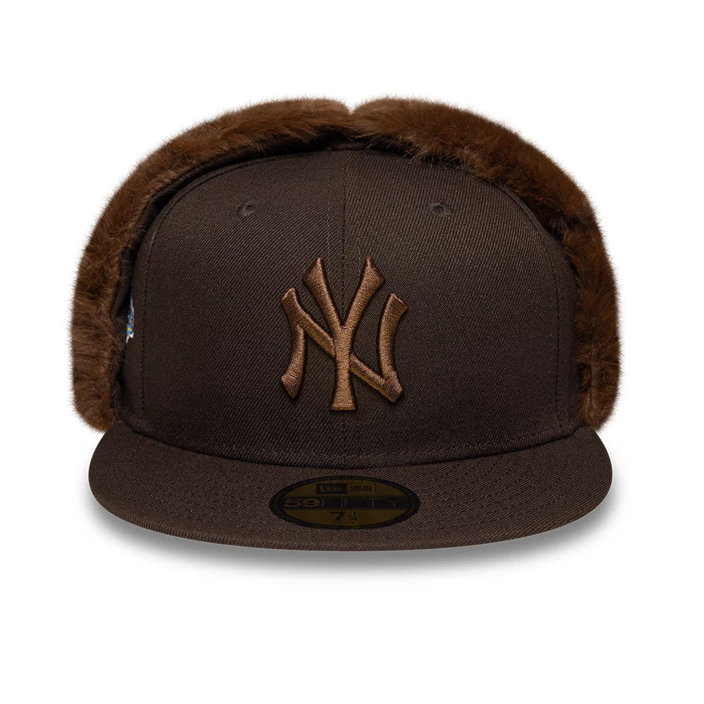 New York Yankees MLB World Series Dark Brown Dogear New Era 59FIFTY Fitted Cap, front view showing a raised brown NY logo on the structured dark brown crown with attached dogears and a gold 59FIFTY size sticker on the flat visor.