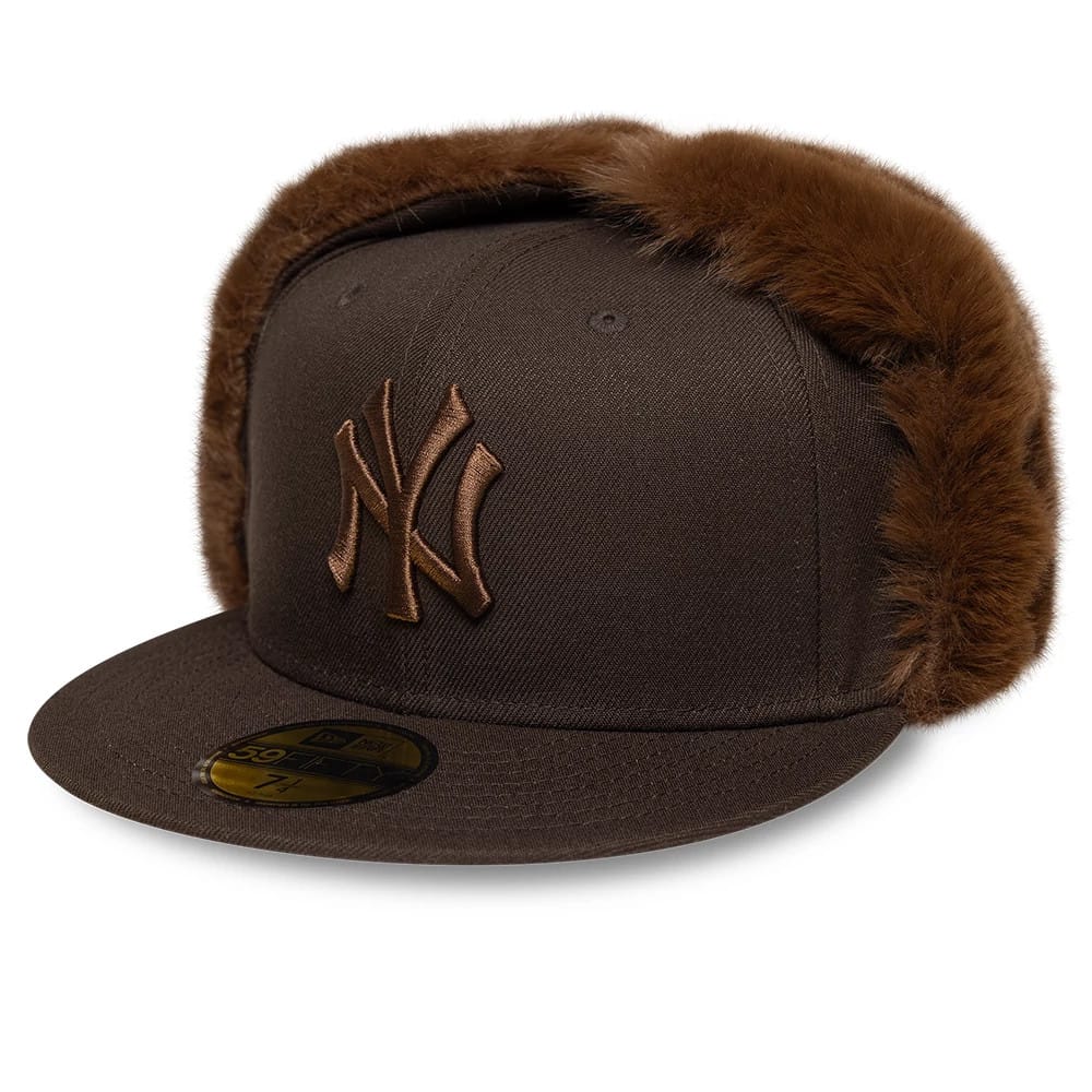New York Yankees MLB World Series Dark Brown Dogear New Era 59FIFTY Fitted Cap, front view showing raised brown NY logo embroidery on the front panel, flat visor visor with a gold 59FIFTY size sticker, and dark brown faux fur dogears.