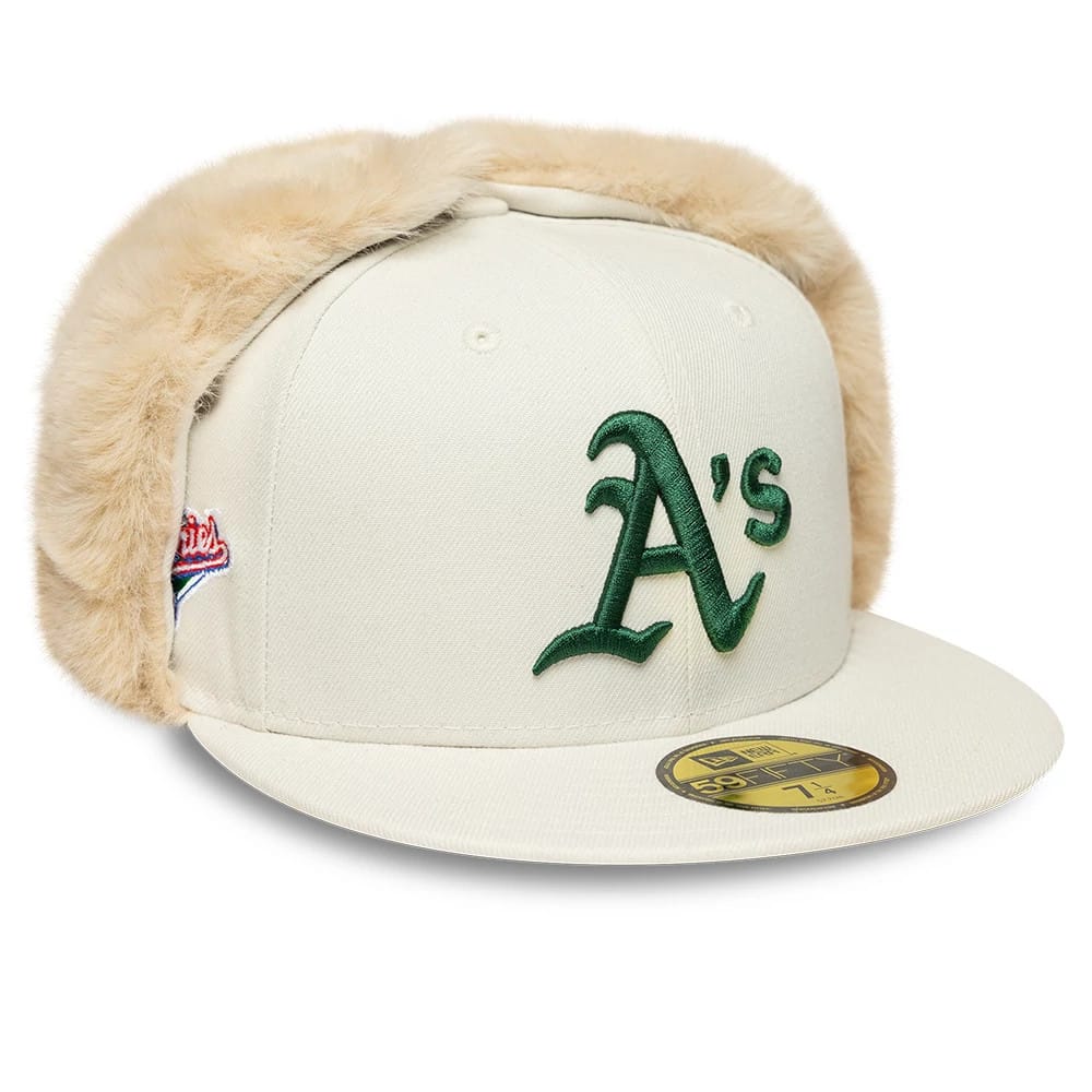 Athletics MLB World Series Cream Dogear New Era 59FIFTY Fitted Cap, three-quarter view showing the green embroidered A's logo on the front panel, cream dogears, and gold 59FIFTY size sticker on the flat cream visor.