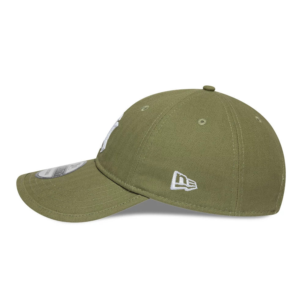 New York Yankees MLB Herringbone Green New Era 9TWENTY Adjustable Cap, side view showing the white embroidered New Era flag logo, curved visor with a 9TWENTY size sticker, and green herringbone-patterned fabric.