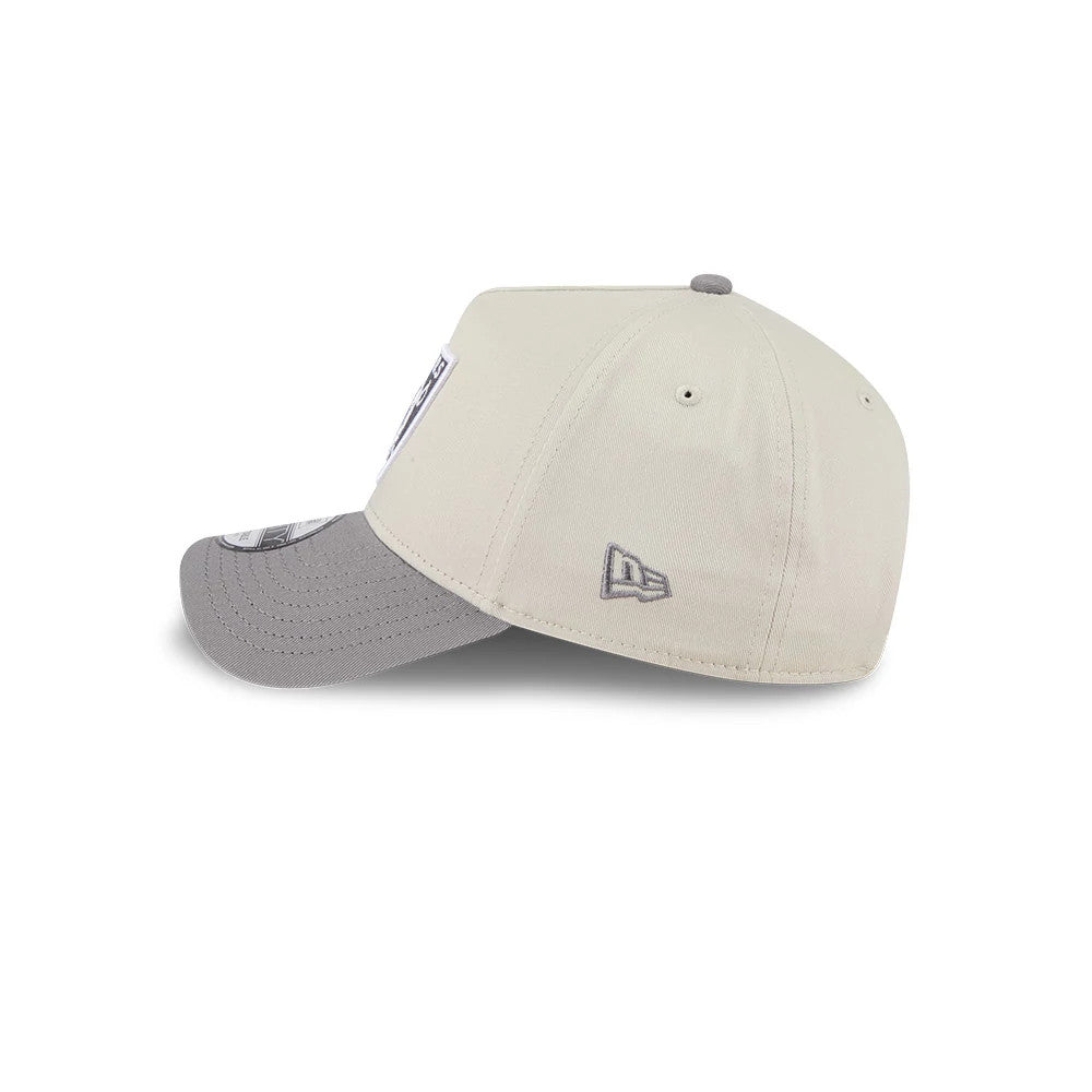 Las Vegas Raiders NFL Stone Storm Light Beige New Era 9FORTY A-Frame Adjustable Cap, side view showing the grey embroidered New Era flag logo on the left side, with a lightly curved grey visor and matching top button.