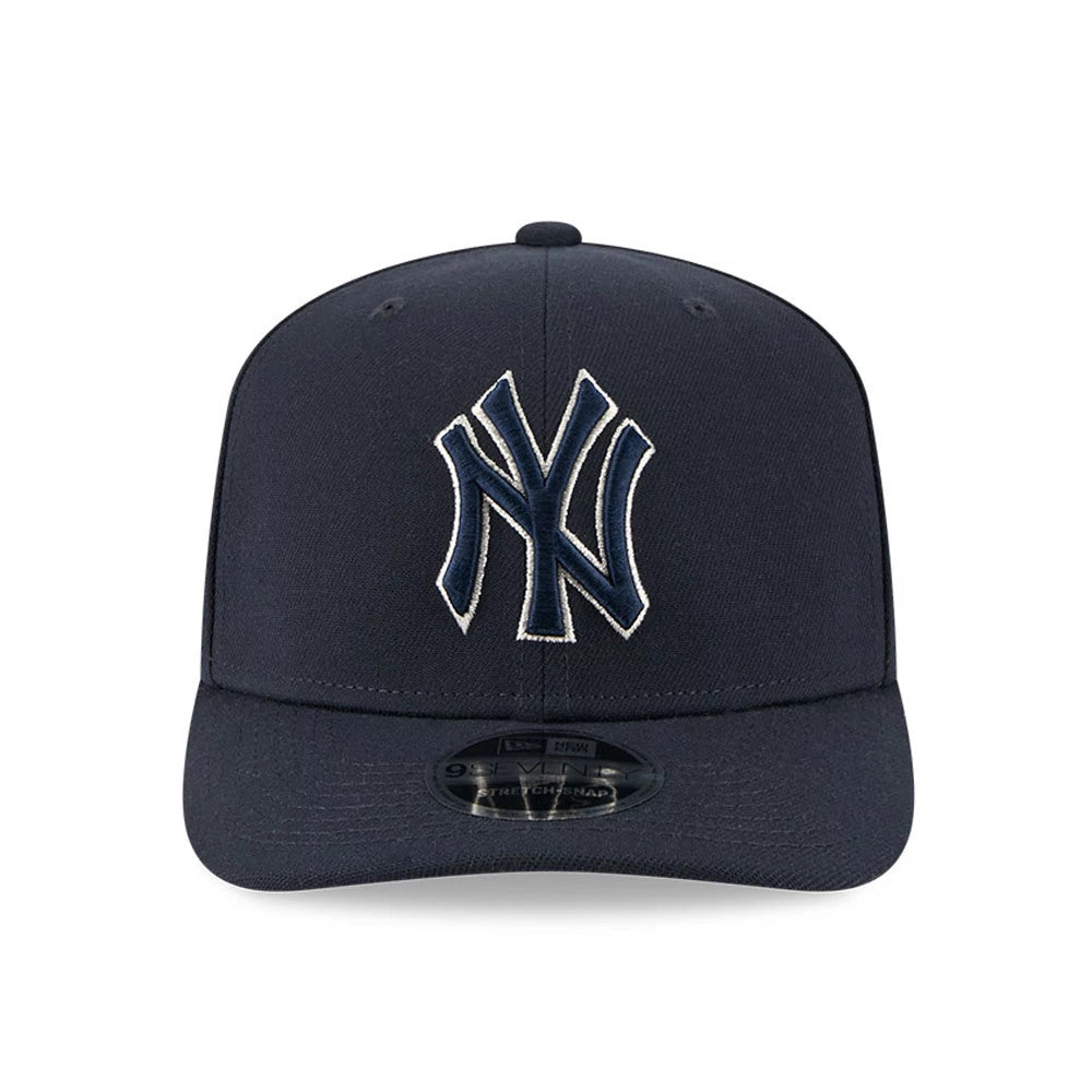 New York Yankees MLB Navy New Era 9SEVENTY Stretch Snap Adjustable Cap, front view showing the raised navy NY logo with white outline embroidered on the front panel, and a black 9SEVENTY size sticker on the curved navy visor.
