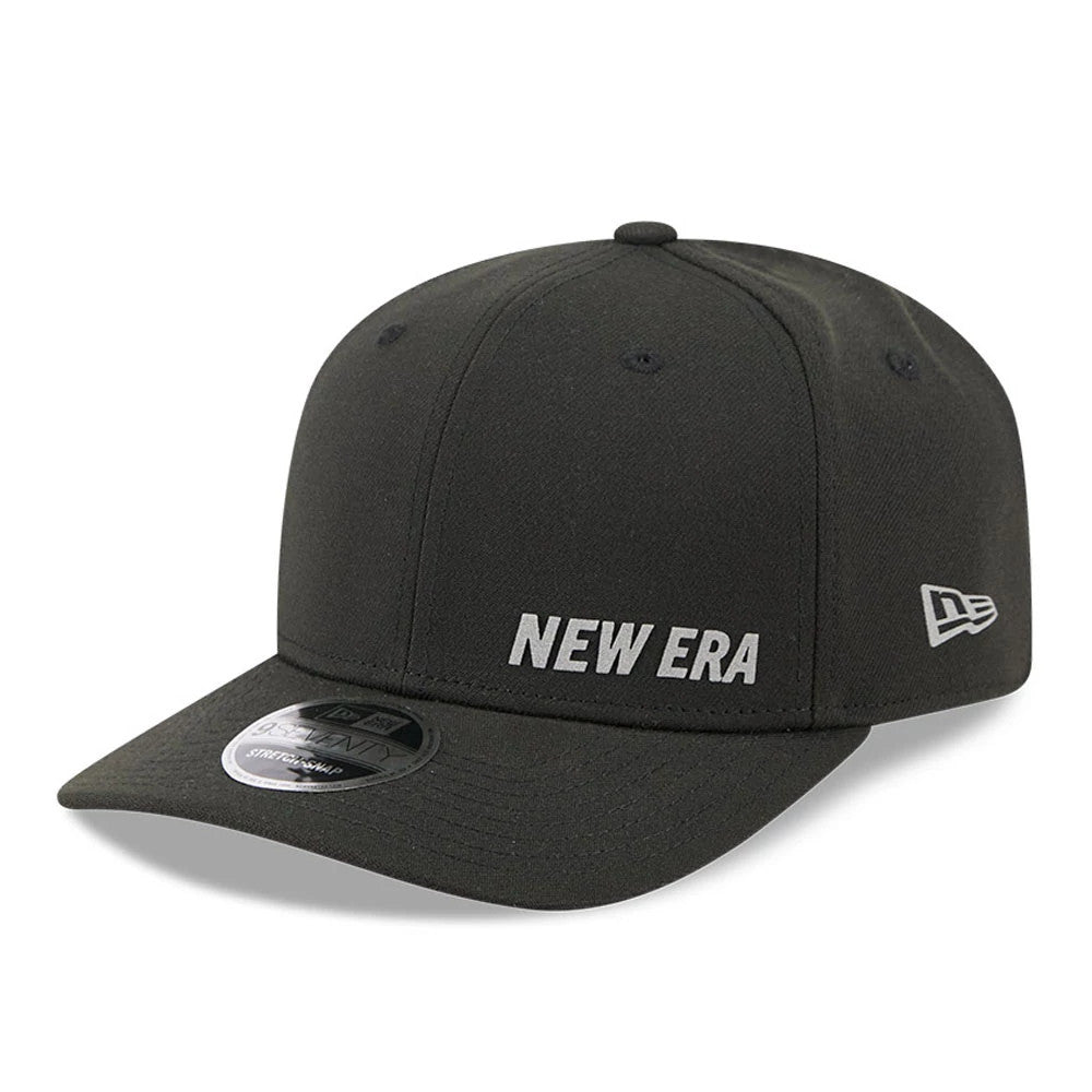 New Era Flawless Black 9SEVENTY Stretch Snap Adjustable Cap, front view showing the white New Era text logo in flat embroidery on the front panel, with a black curved visor and 9SEVENTY size sticker, and white flag logo on the left side.