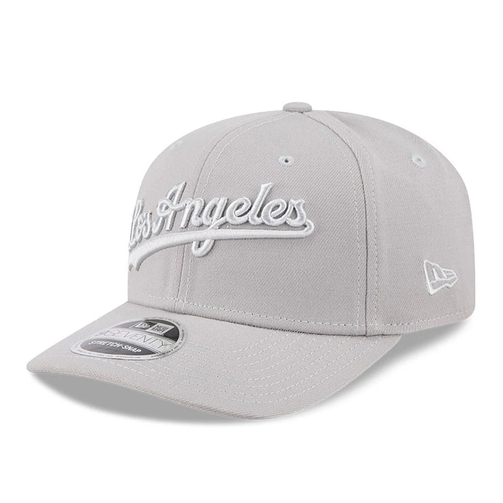 LA Dodgers MLB Script Grey New Era 9SEVENTY Stretch Snap Adjustable Cap, front view showing raised white Los Angeles script embroidery on the front panel, a grey curved visor with a 9SEVENTY size sticker.