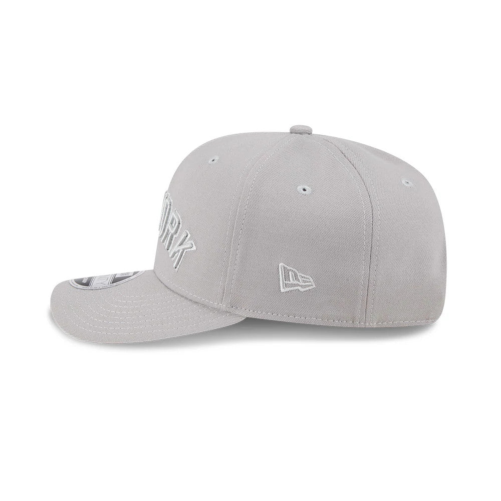 New York Yankees MLB Script Grey New Era 9SEVENTY Stretch Snap Adjustable Cap, side view showing the white embroidered New Era flag logo on the left side and a grey pre-curved visor with a 9SEVENTY size sticker on top.