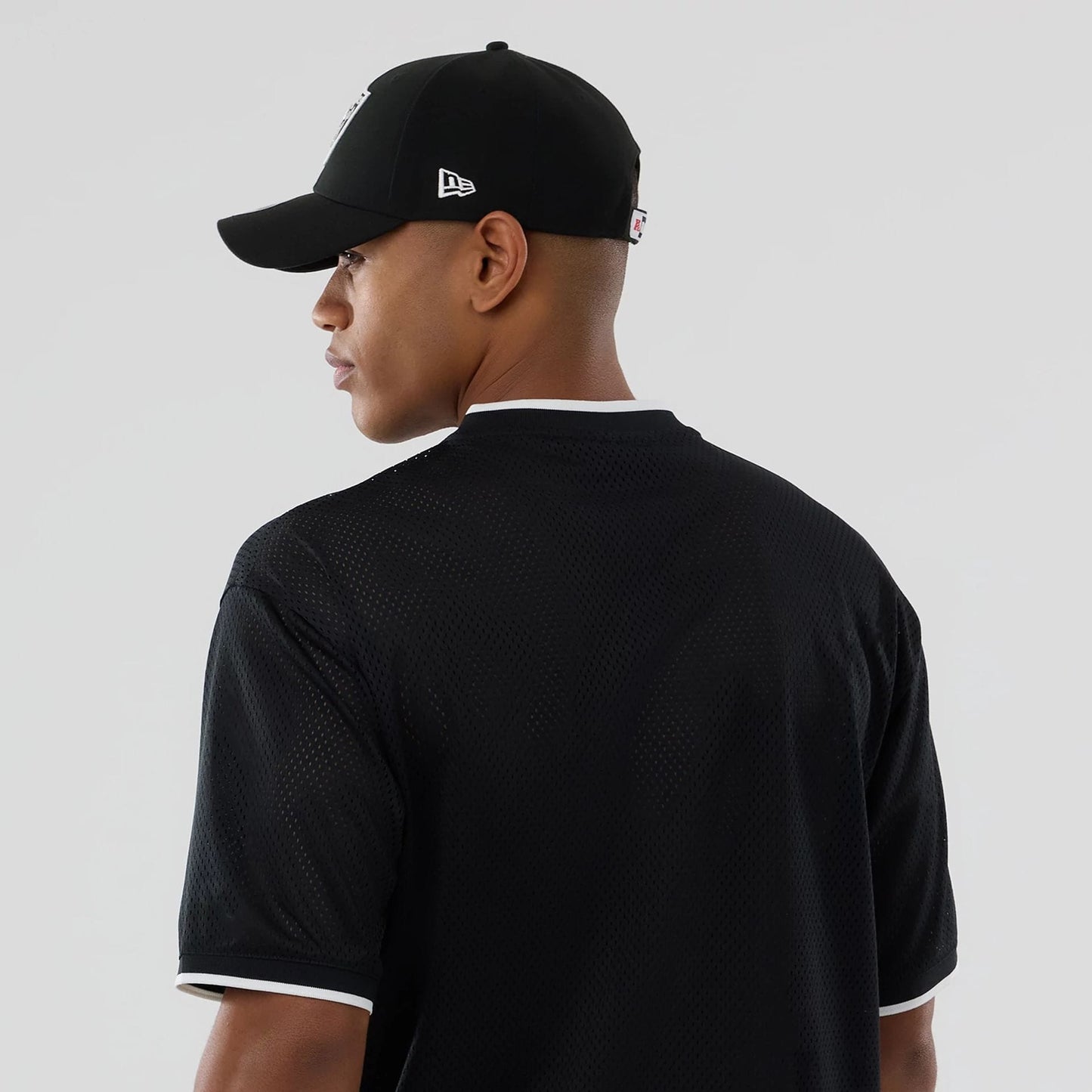 The model is wearing this NFL Mesh Las Vegas Raiders Oversized T-Shirt in black. 7