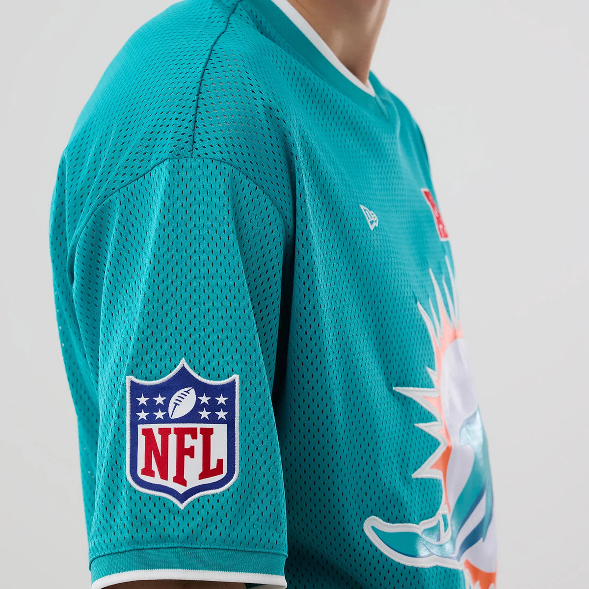 The model is wearing this NFL Mesh Miami Dolphins Oversized T-Shirt in turquoise. 3