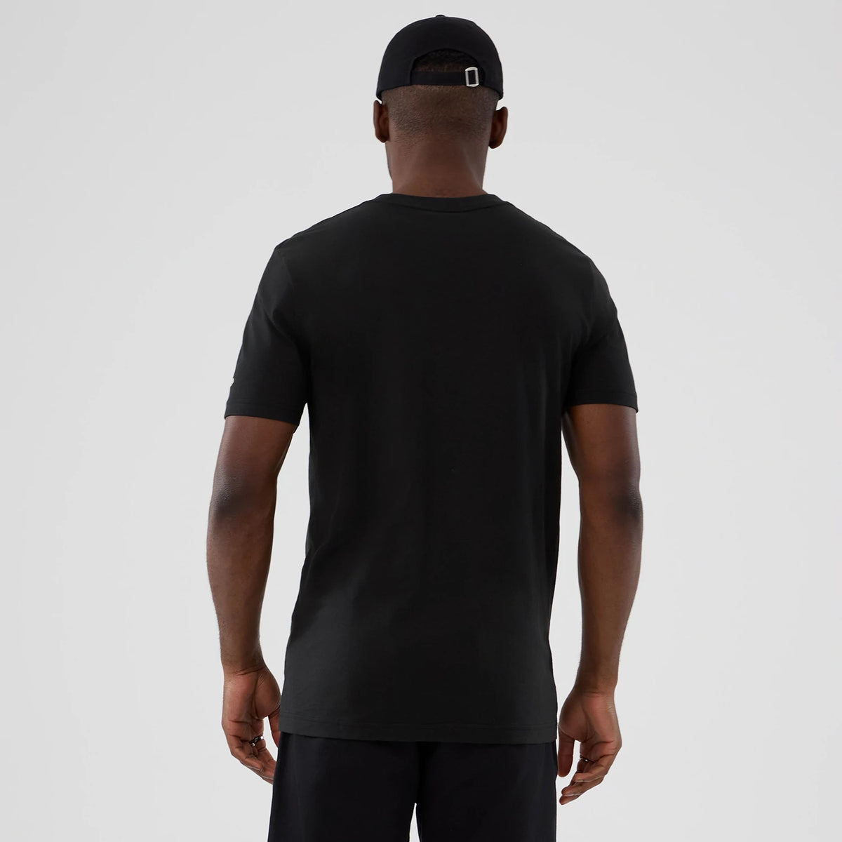 New Era Denver Nuggets NBA Hardwood Classic Black T-Shirt, back view on a model with a black cap, showcasing a clean solid black design with short sleeves and a round neck extending to mid-thigh length.