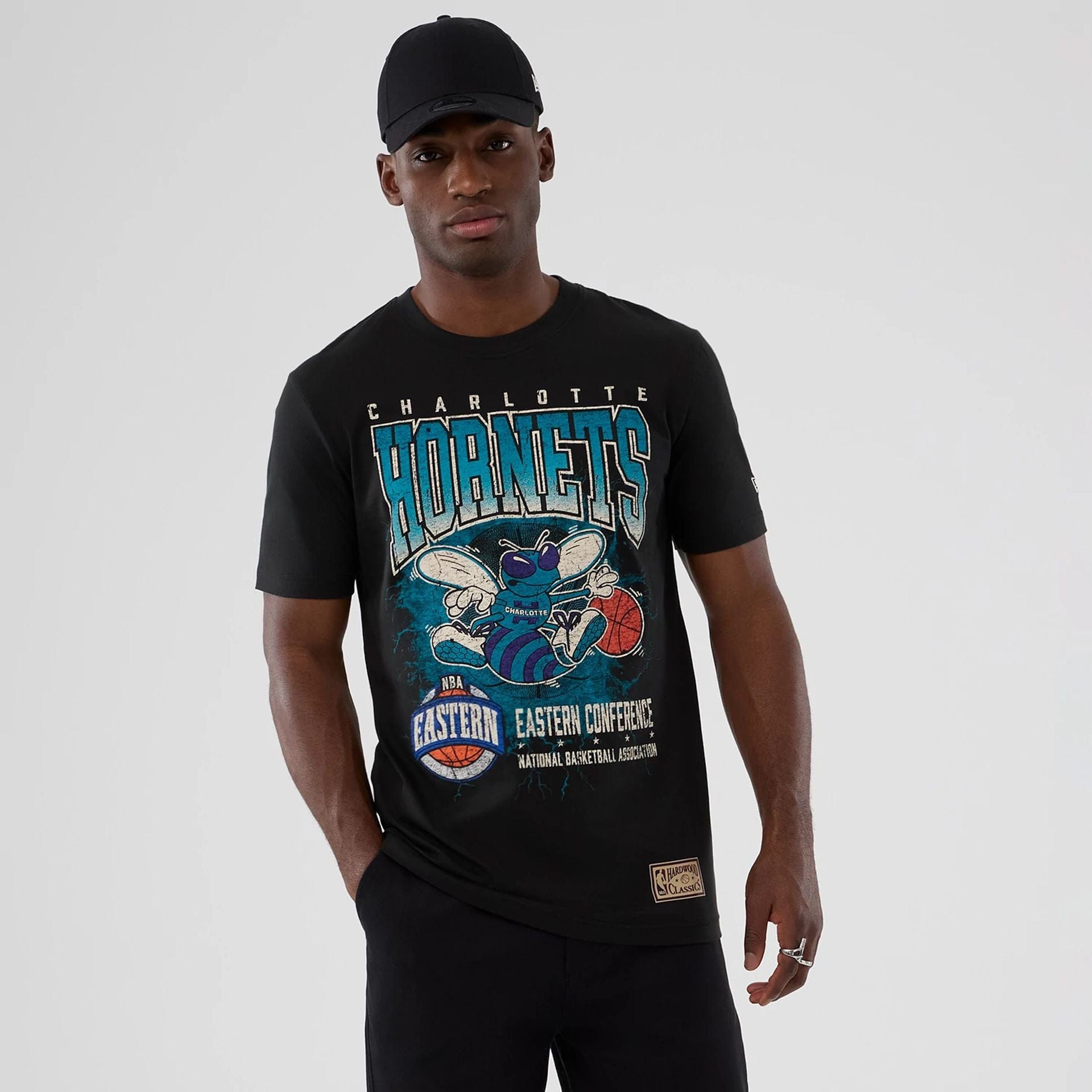 The model is wearing this NBA Hardwood Classic Charlotte Hornets T-Shirt in black. 1