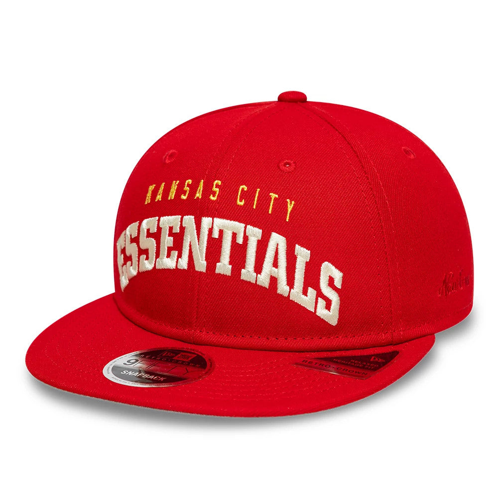 Kansas City Chiefs Fear Of God x NFL Red Retro Crown New Era 9FIFTY Adjustable Cap, three-quarter view showing white embroidered ESSENTIALS text on the front panel, yellow KANSAS CITY text above, and a 9FIFTY size sticker on the flat red visor.