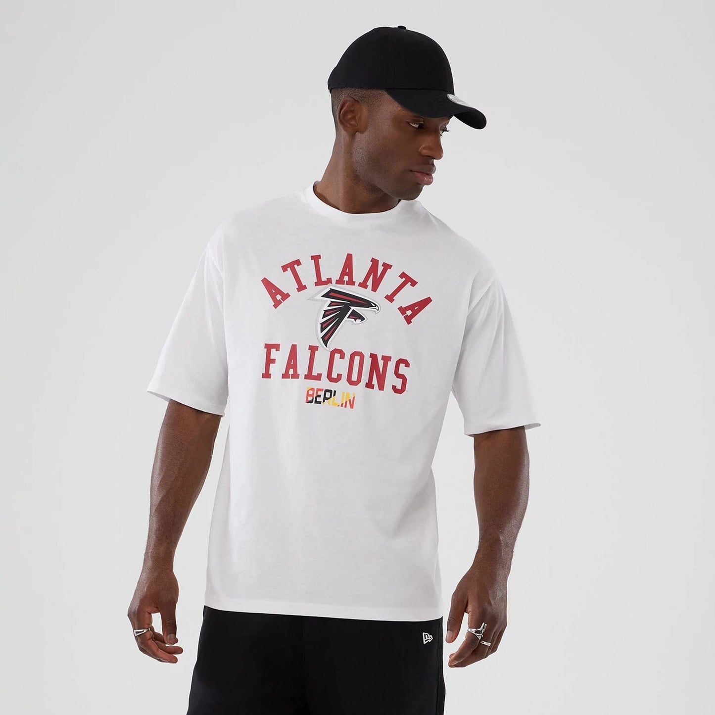 The Male model is wearing Atlanta Falcons NFL International Series Games 2025 White Oversized T-Shirt 7