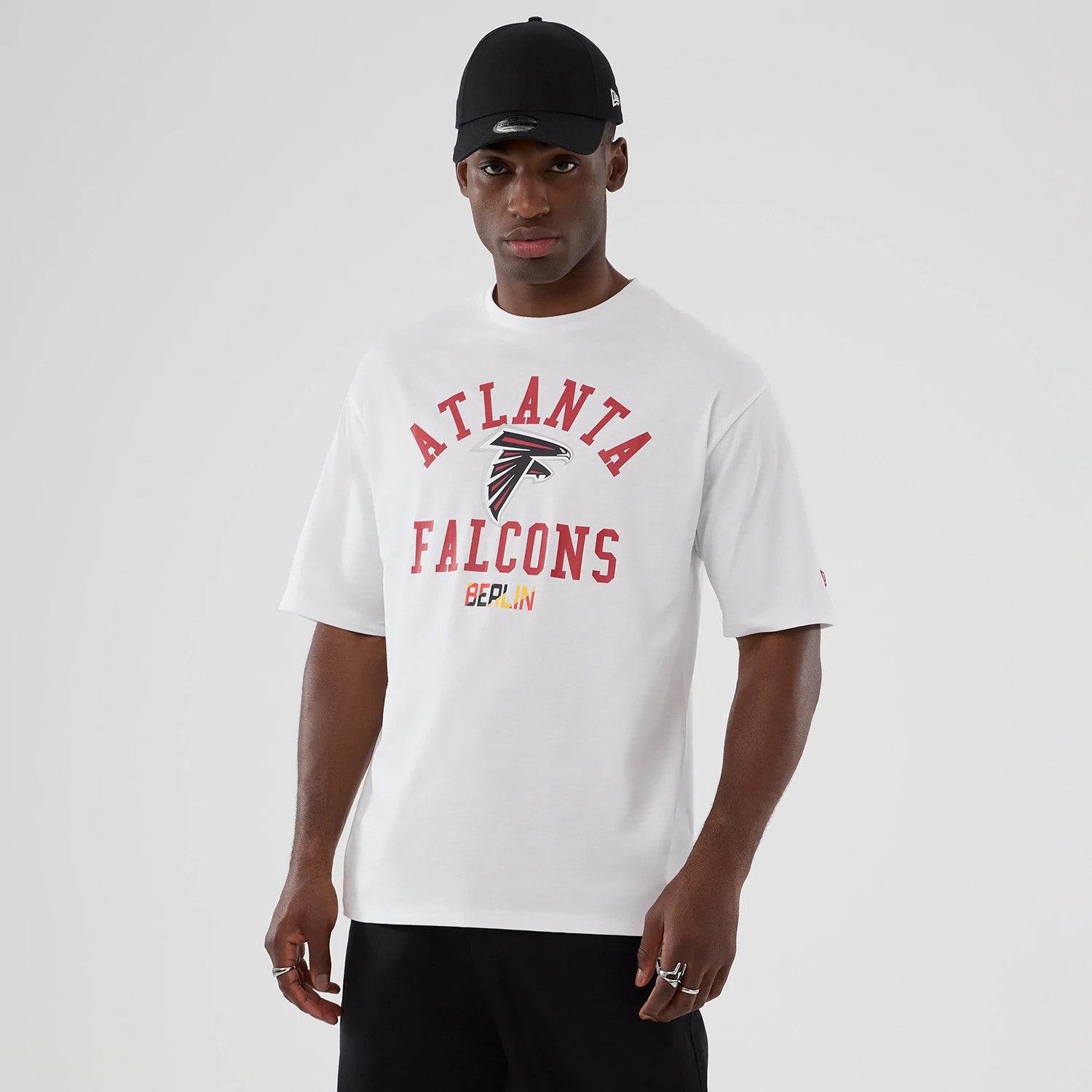 The Male model is wearing Atlanta Falcons NFL International Series Games 2025 White Oversized T-Shirt 1