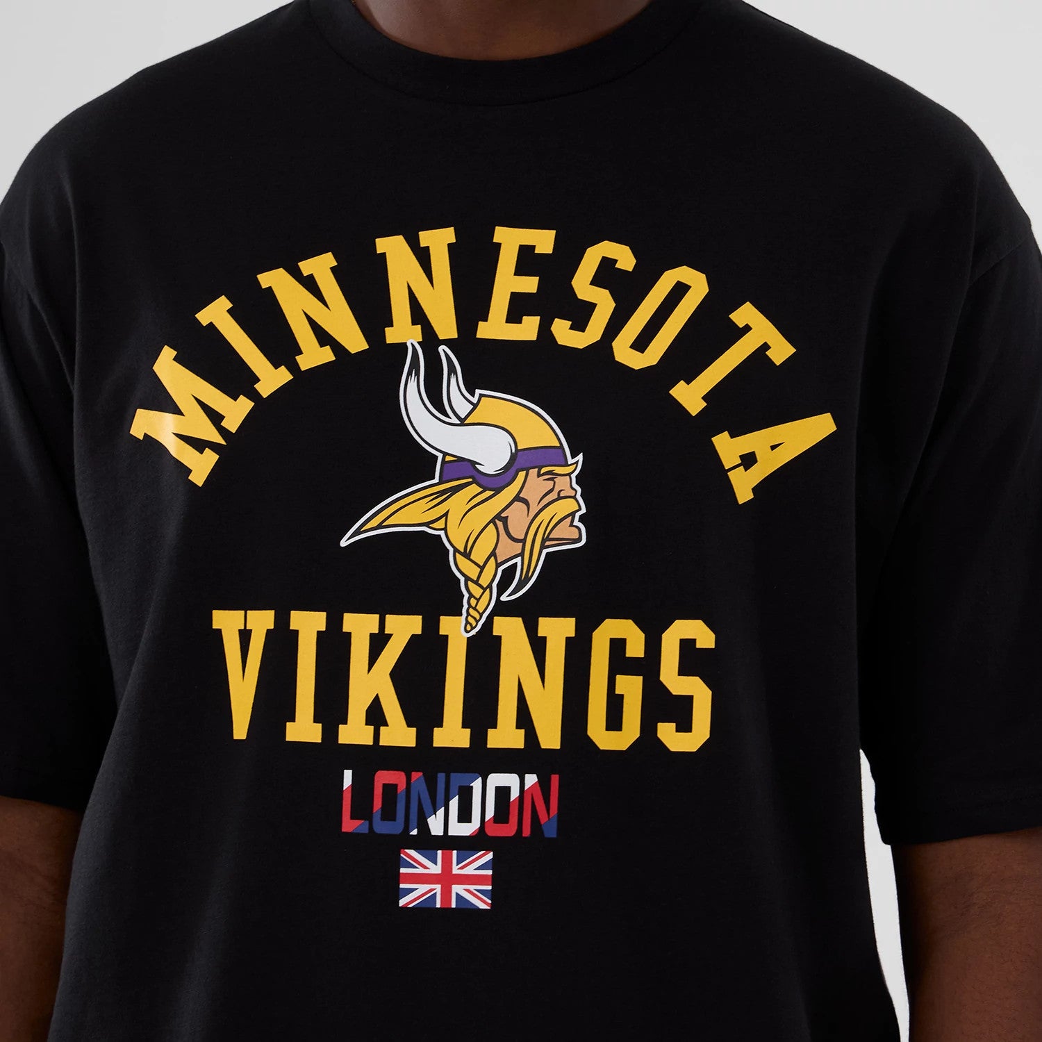 The Male model is wearing Minnesota Vikings NFL International Series Games 2025 Black Oversized T-Shirt 3